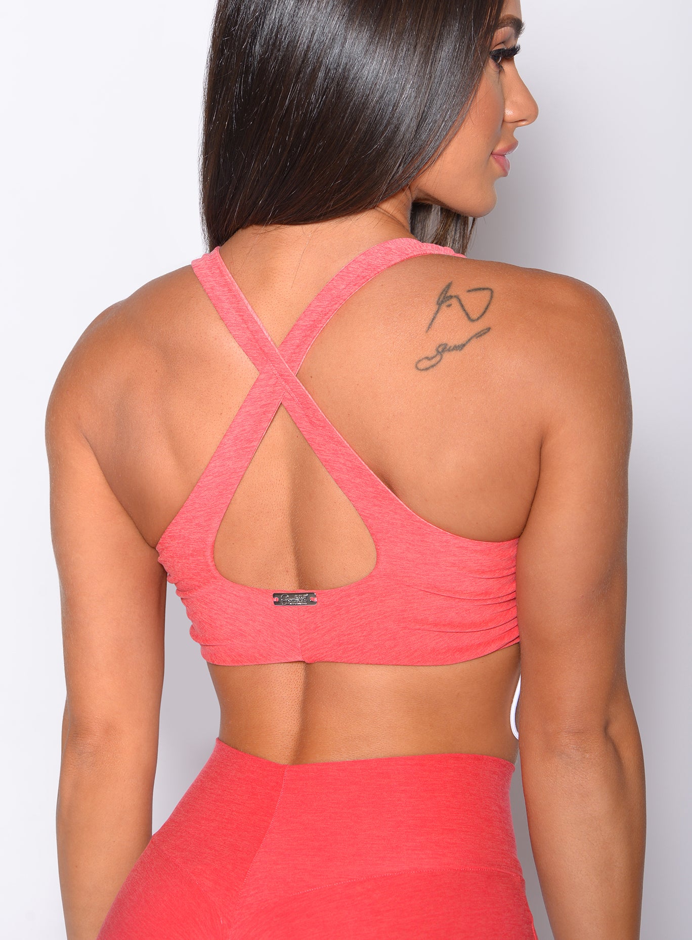 Zoomed in back view of our toggle sports bra in Ombre Fiji Coral color 