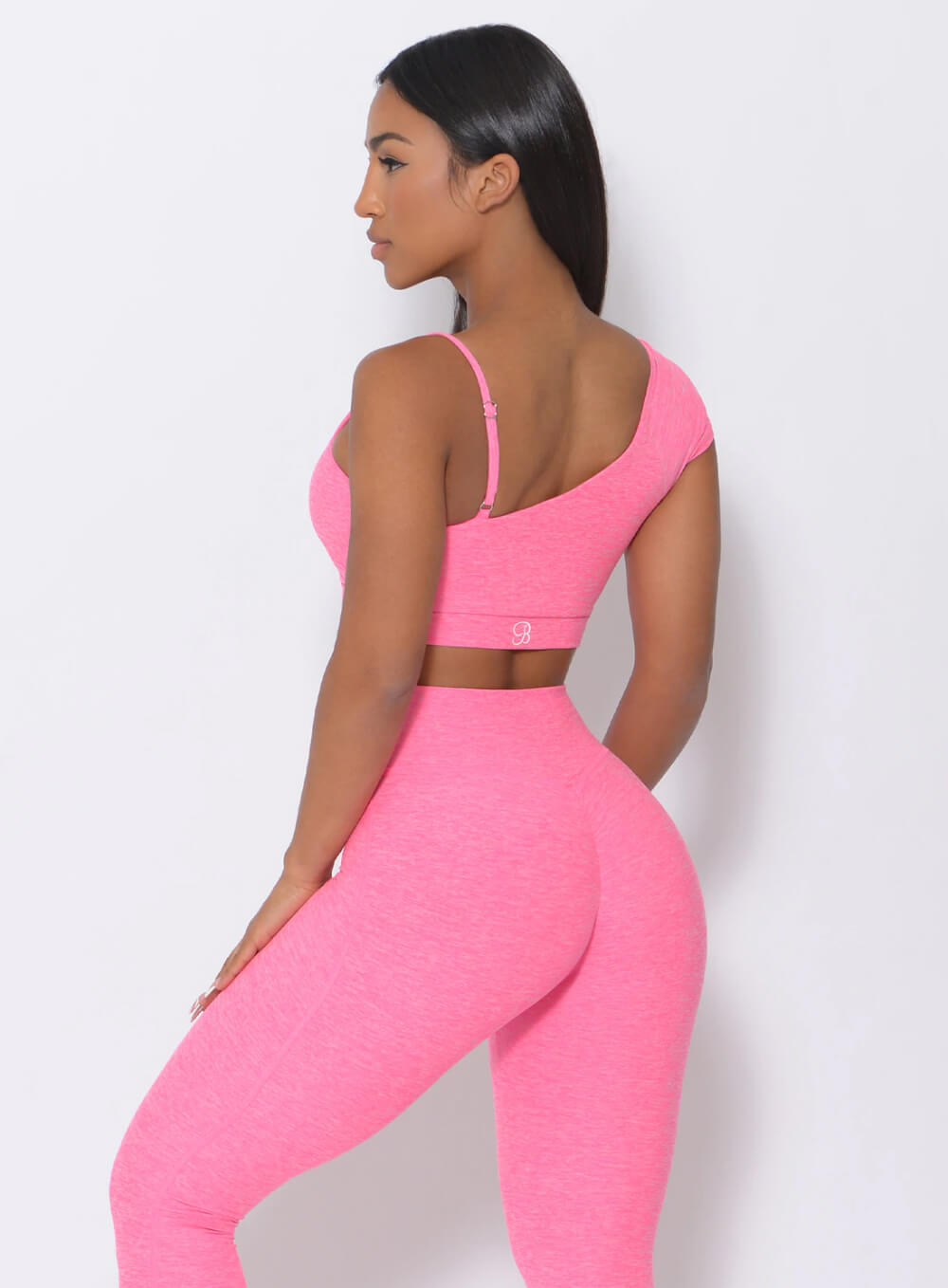 Left side view of the model wearing our Adore Sports Bra in pink and a matching leggings