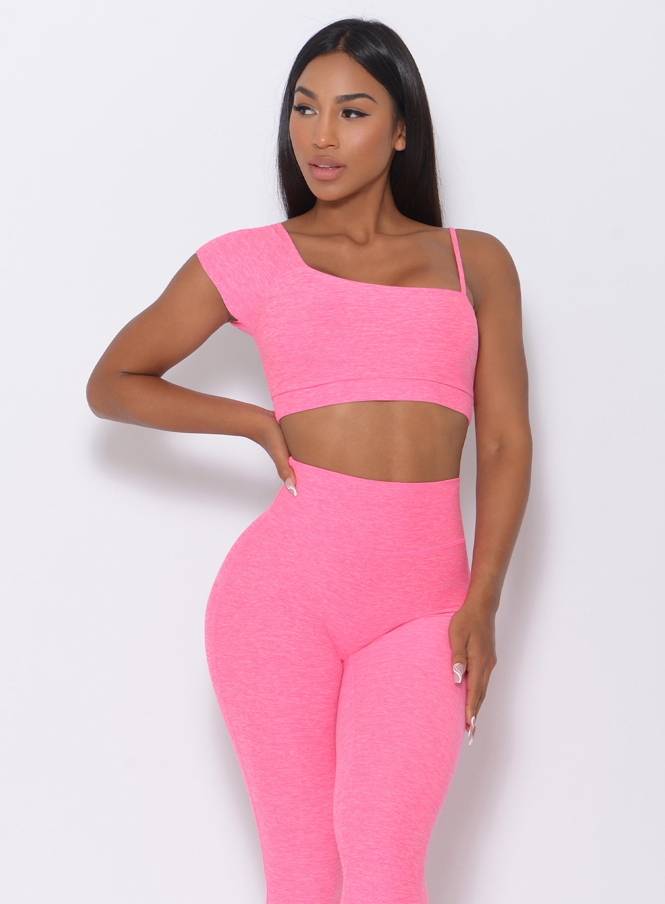 front profile view of the model in our Adore Sports Bra in pink and a matching leggings