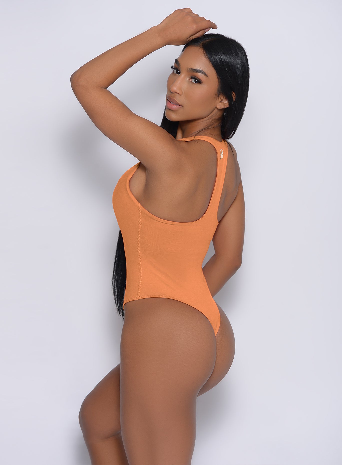 Left side  profile view of a model in our perfect bodysuit in honeycomb color 