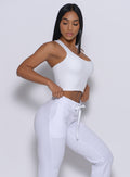 Right side  profile view of a model in our white elevated tank bra and a matching joggers