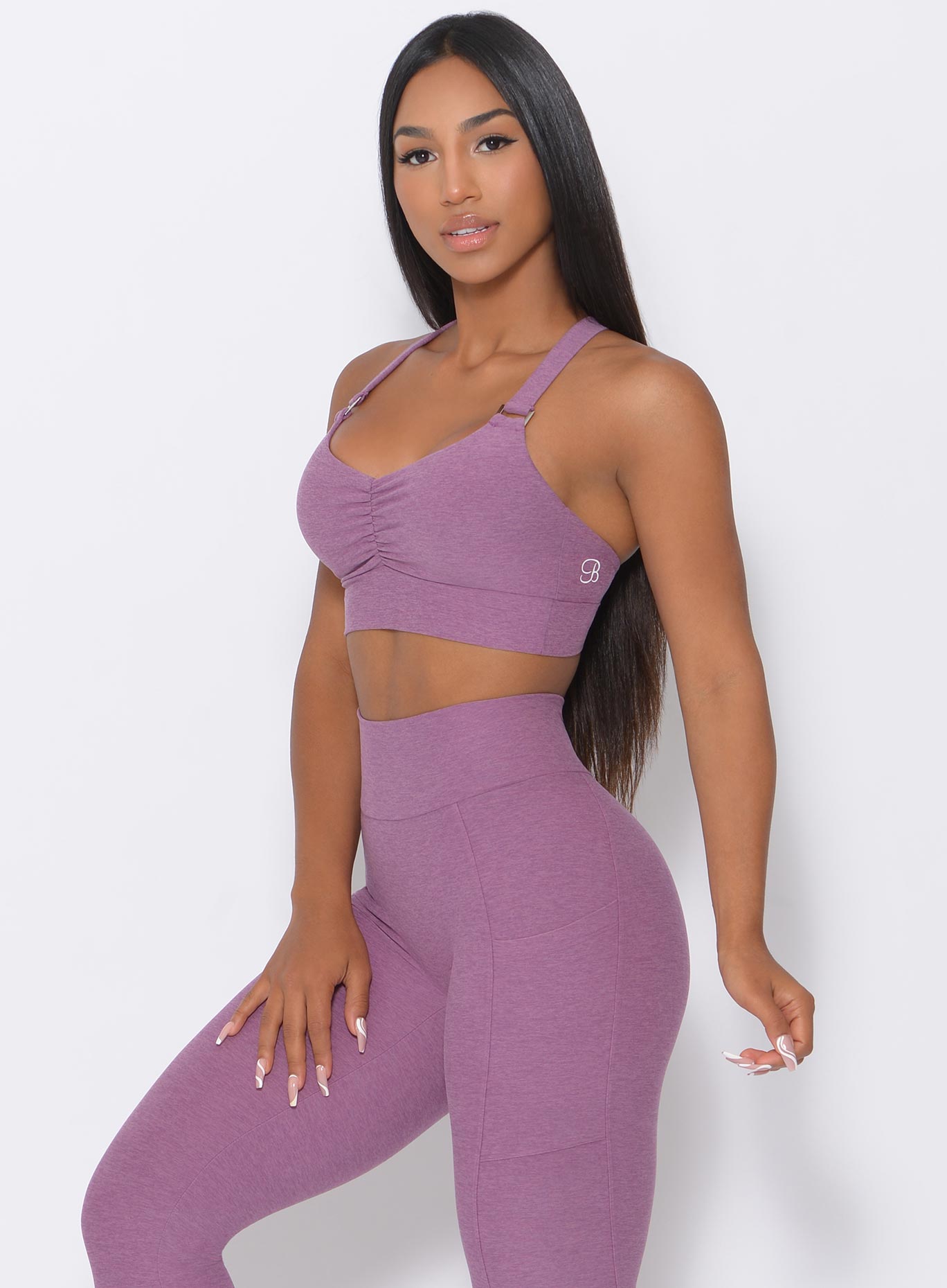 Left side view of the model angled left wearing our perfection sports bra in lavender and a matching shorts