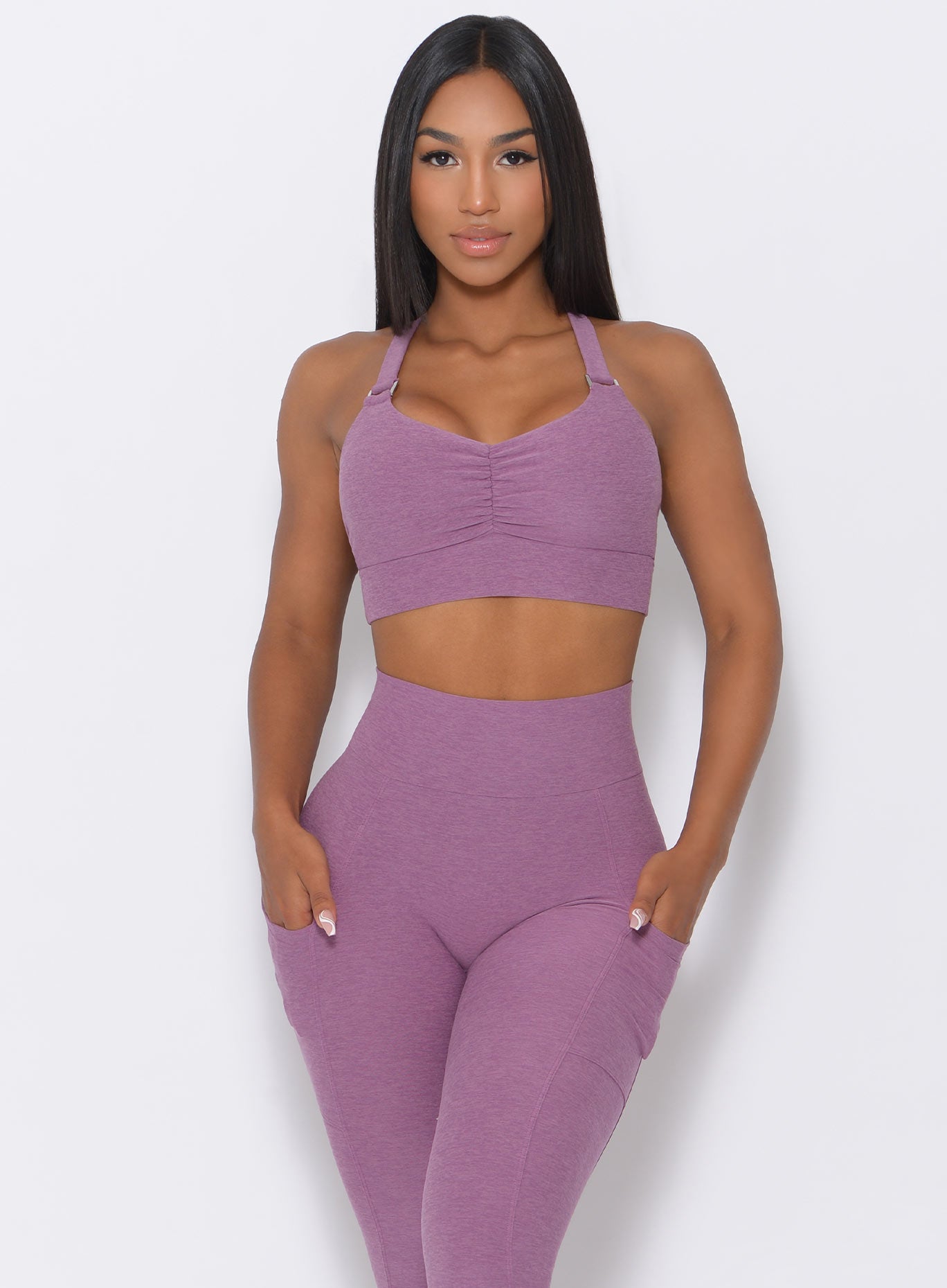 Front profile view of the model wearing our perfection sports bra in lavender and a matching leggings