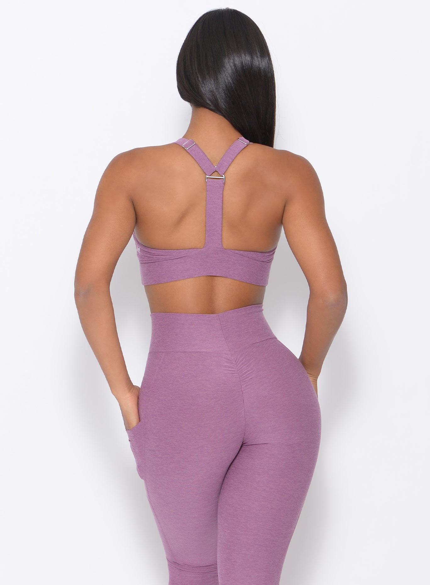back view of the model wearing our perfection sports bra in lavender and a matching leggings