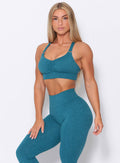 Three quarters view of the model  wearing our perfection sports bra in seafoam color and a matching leggings