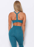 back view of the model  wearing our perfection sports bra in seafoam color and a matching leggings