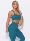 Right side view of the model angled right  wearing our perfection sports bra in seafoam color and a matching leggings