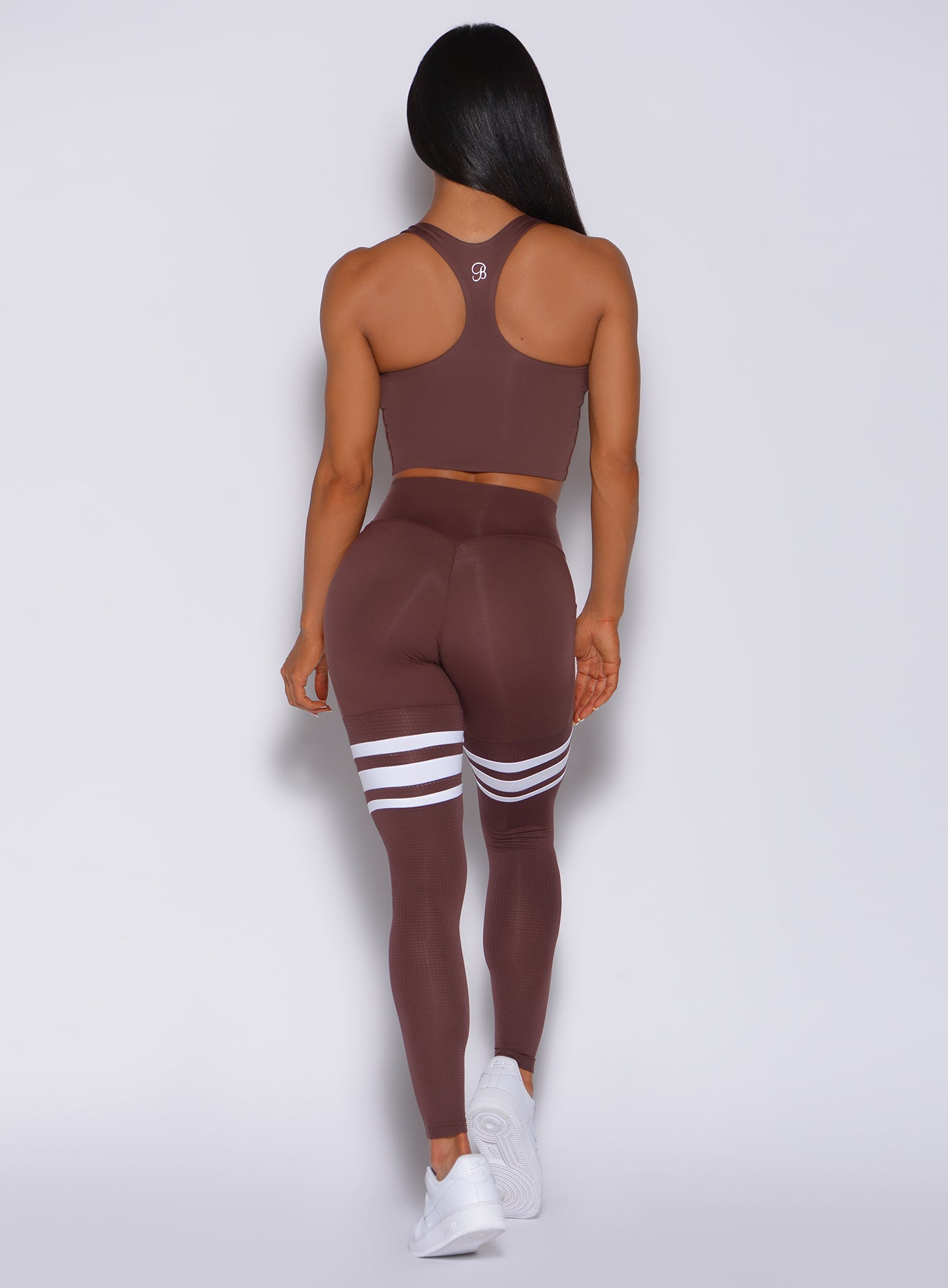 Back  profile view of a model in our perform thigh high in chocolate color and a matching bra