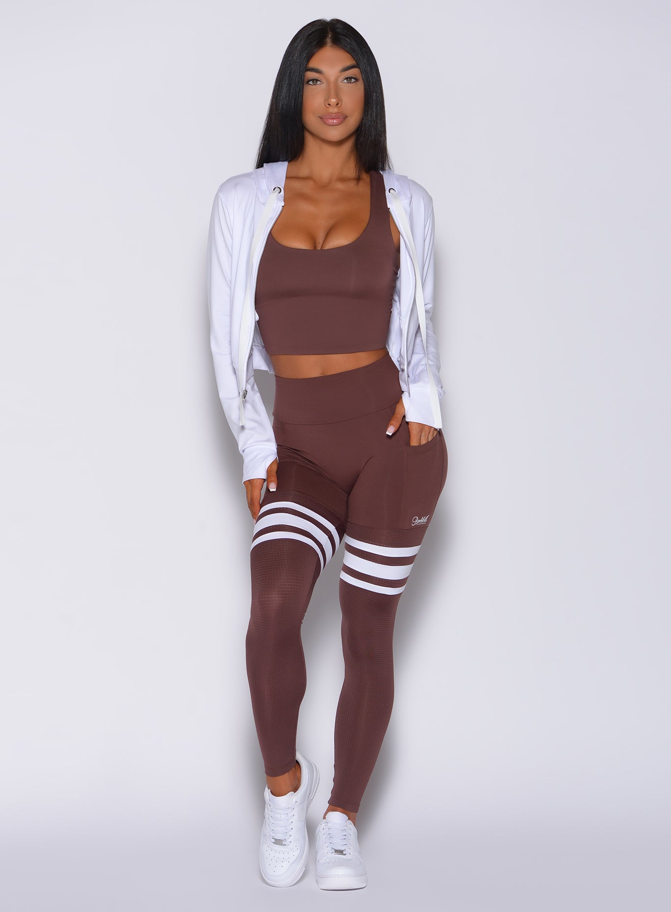 Front  profile view of a model facing forward wearing  our perform thigh high in chocolate color and a matching bra