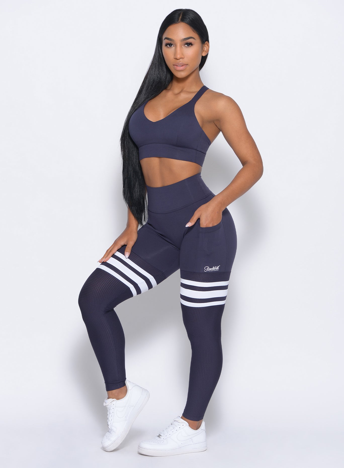 Front profile view of the model wearing our perform thigh highs in twilight blue color and a matching bra