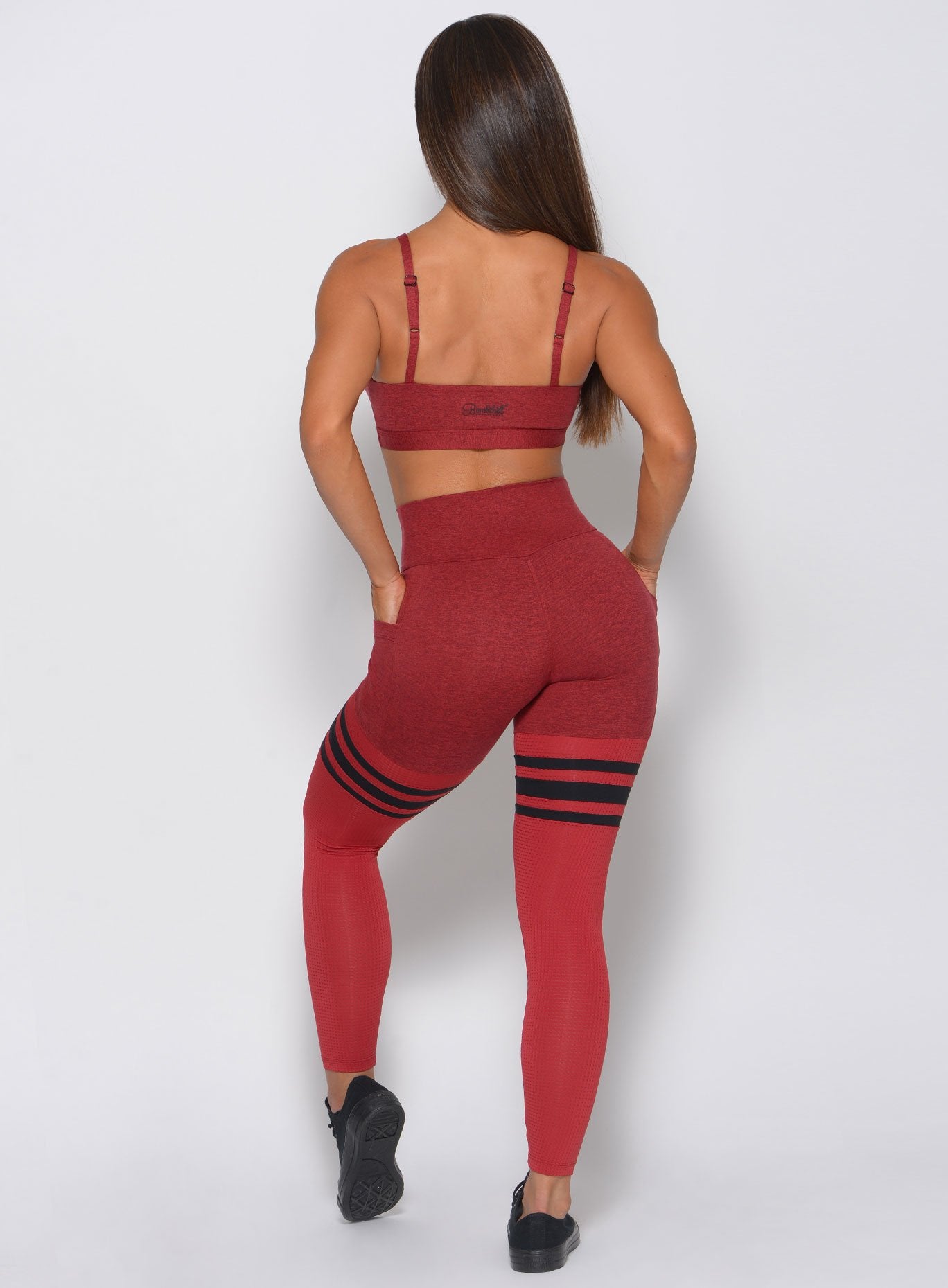 Model facing back wearing maroon/red sports bra and matching high waist leggings