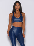 Front profile view of a model wearing our power gloss bra in navy and a matching gloss leggings
