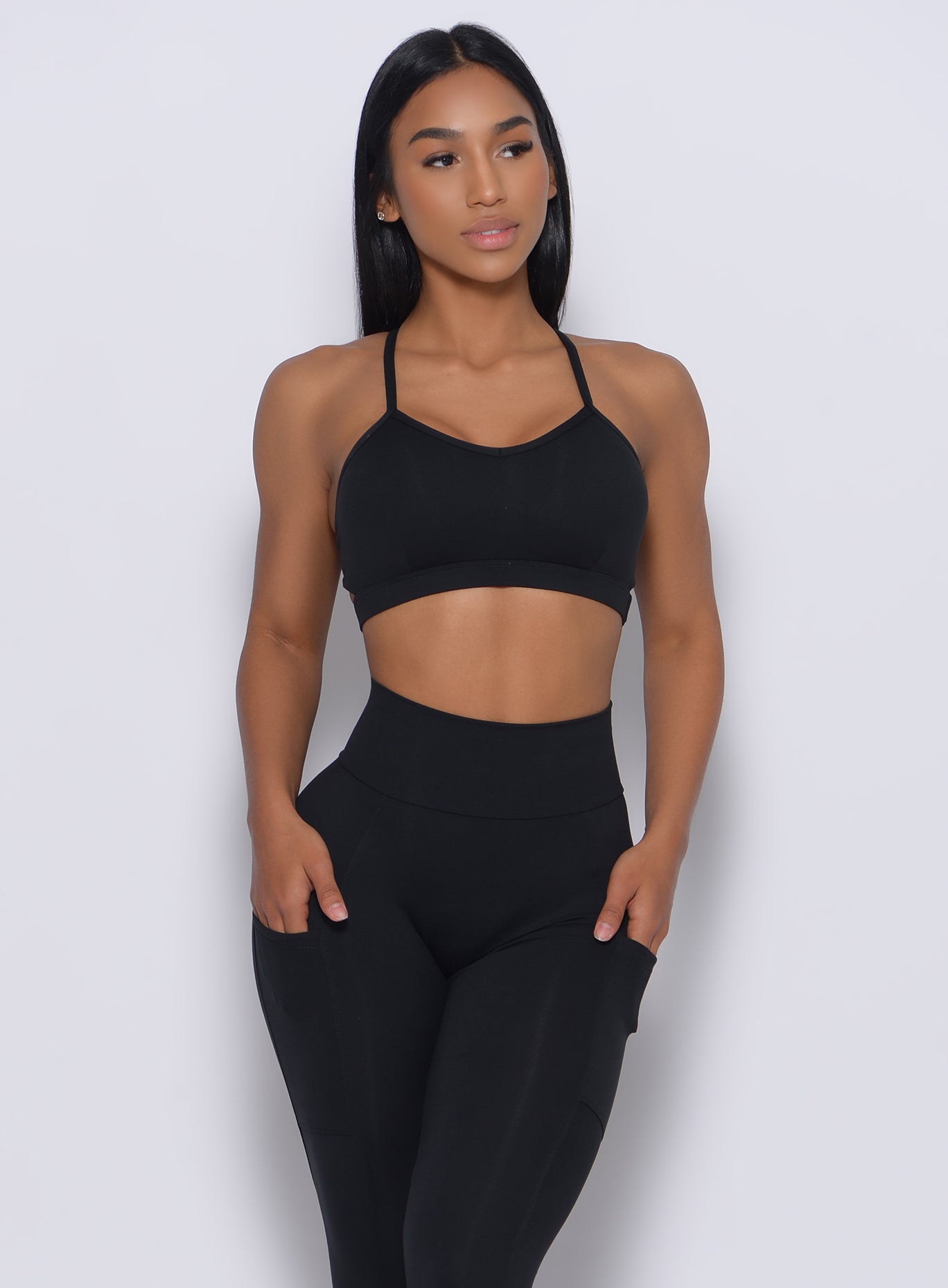Front profile view of a model in our black pumped sports bra and a matching leggings 