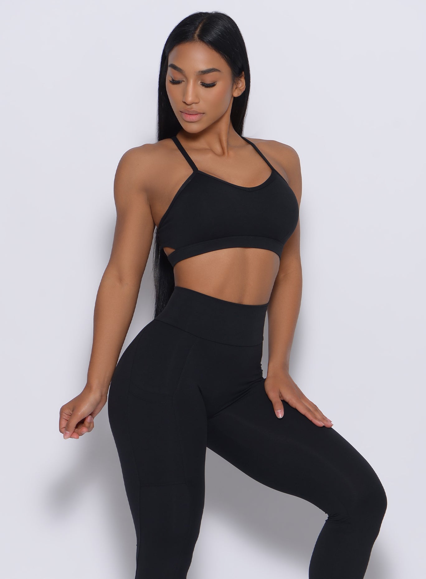 Right side profile view of a model angled right wearing our black pumped sports bra and a matching leggings