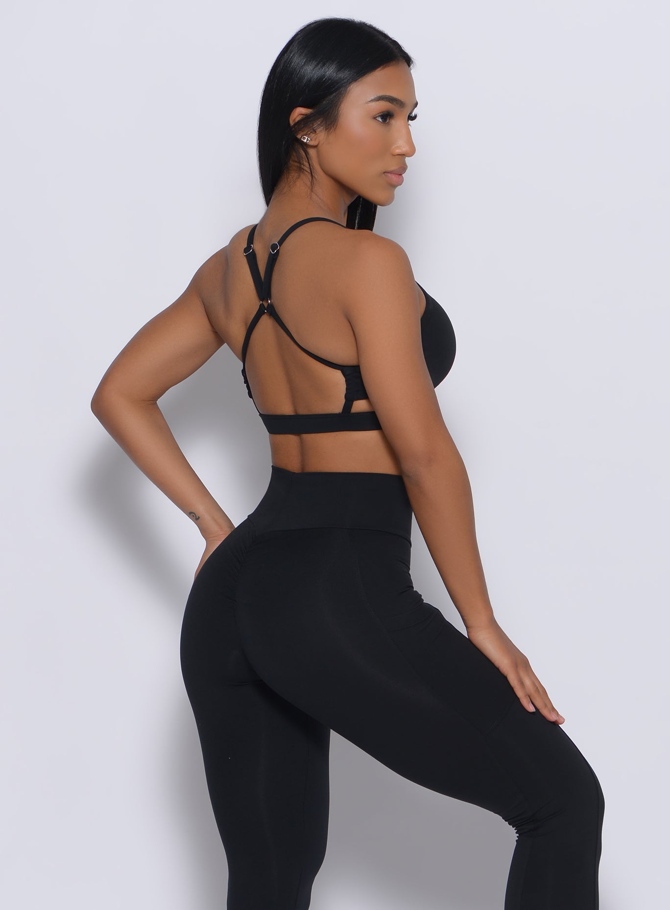 Right side profile view of a model wearing our black pumped sports bra and a matching leggings