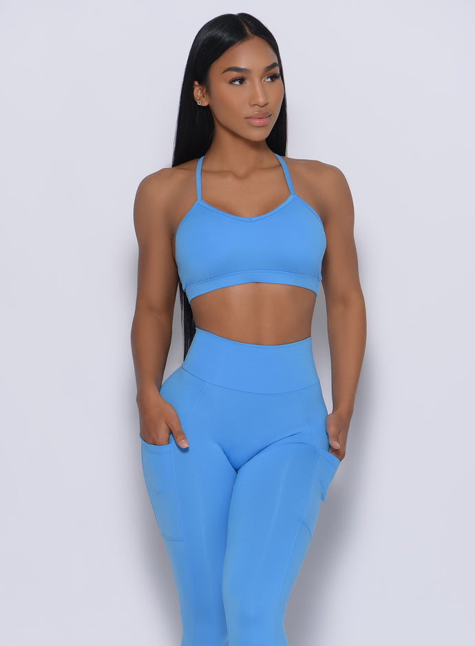 Front profile view of a model in our pumped sports bra in blazing blue color and a matching leggings