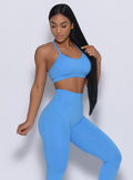 Front profile view of a model wearing our pumped sports bra in blazing blue color and a matching leggings