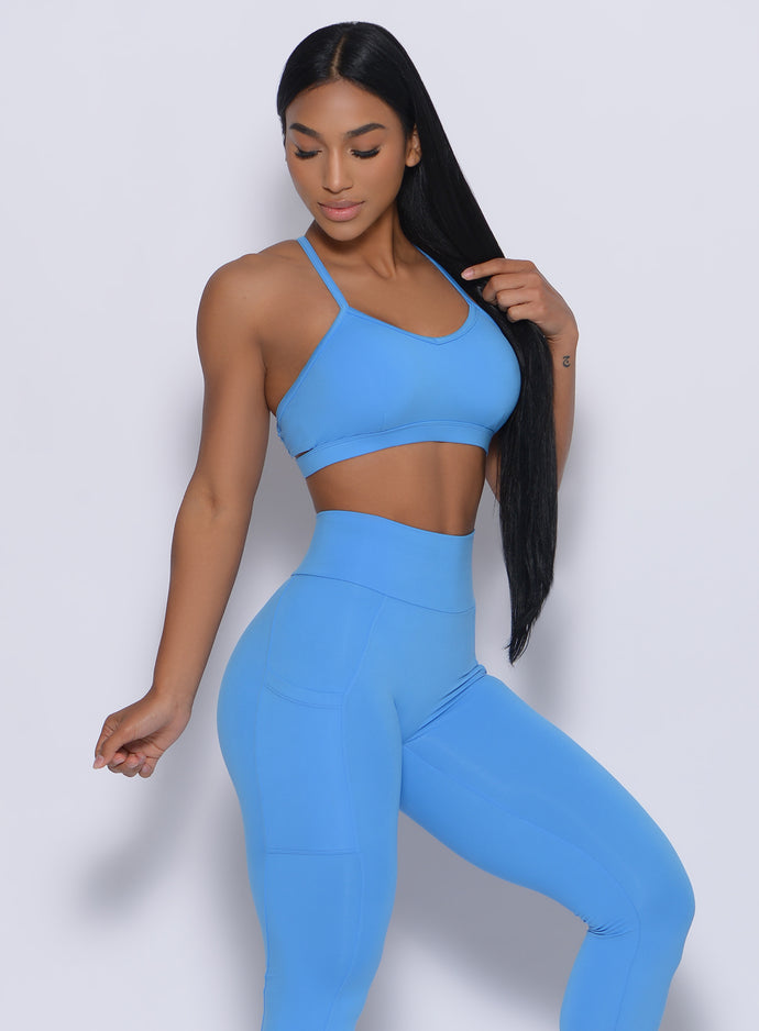 Front profile view of a model wearing our pumped sports bra in blazing blue color and a matching leggings
