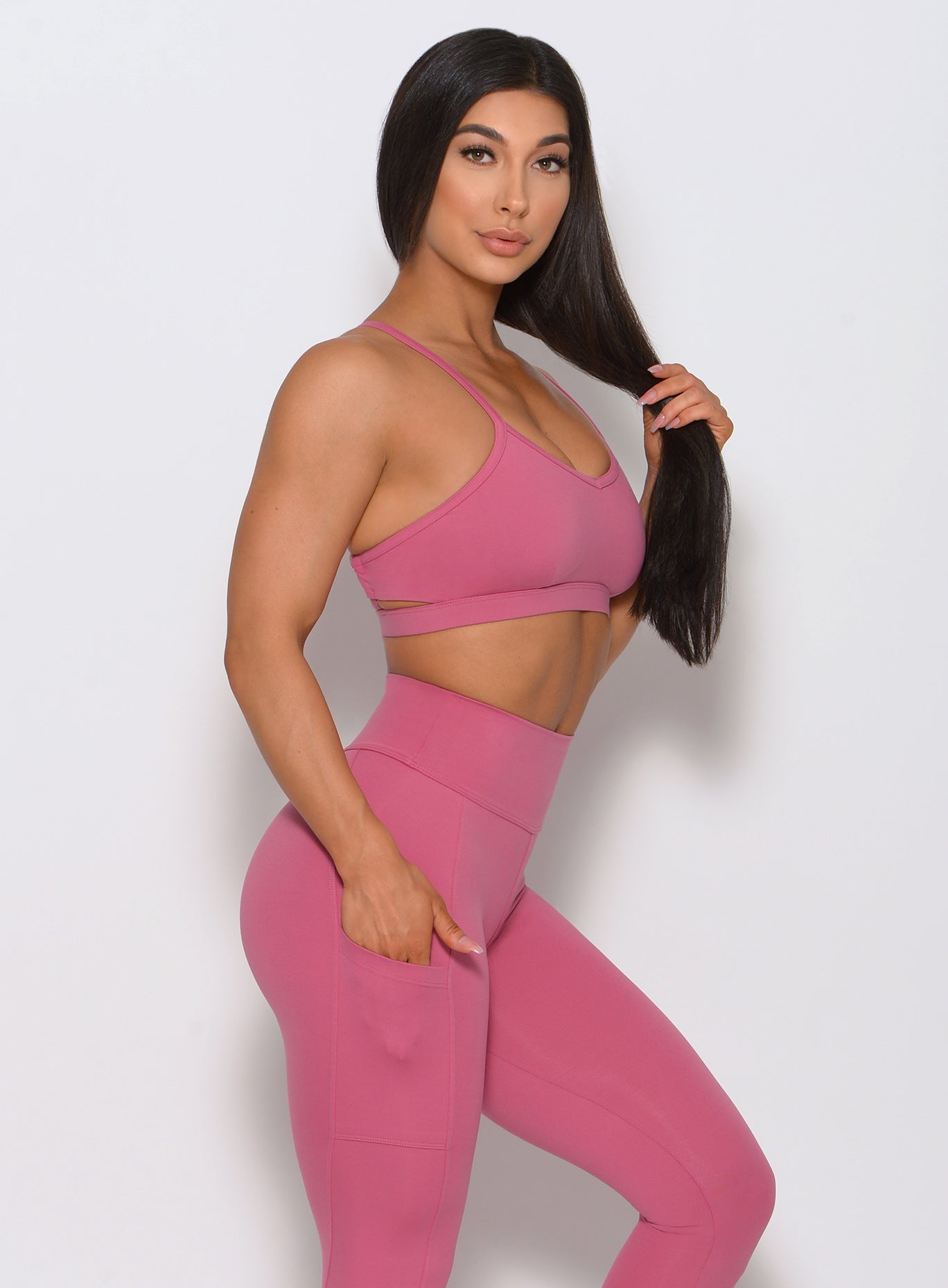 Right side view of the model wearing our pumped sports bra in blush color and a matching high waist leggings