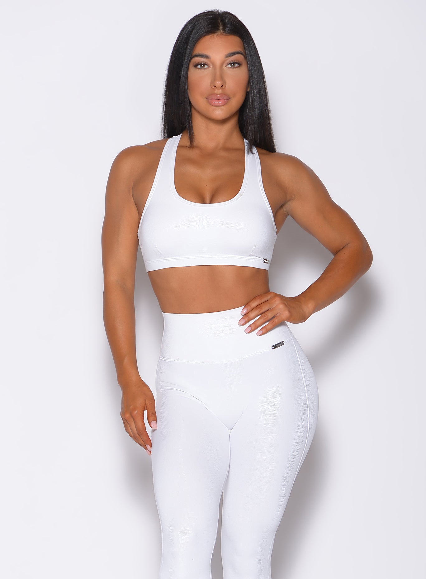 Front profile view of a model wearing our shine sports bra in white python color and a matching leggings