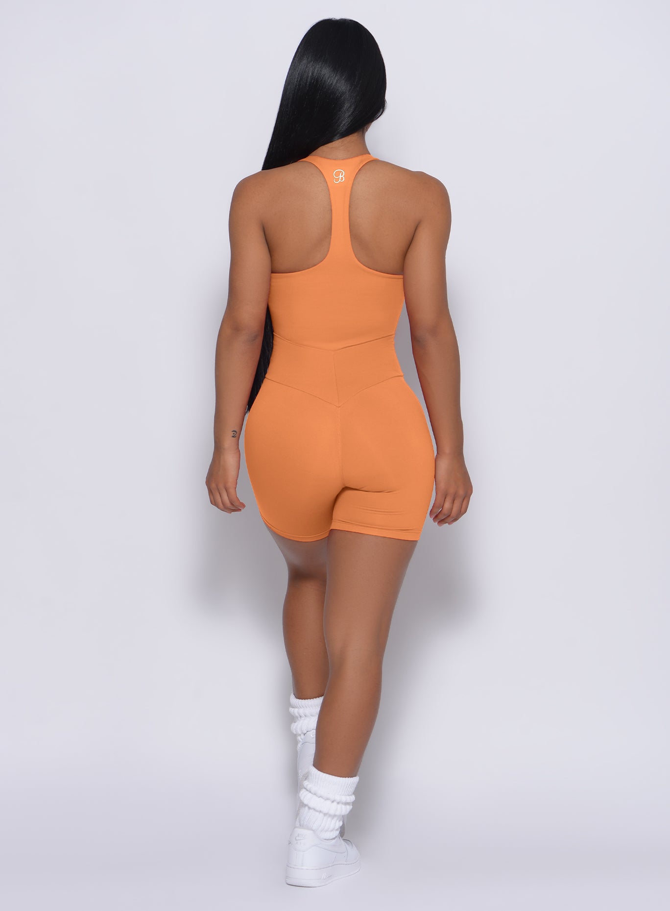 Back profile view of a model in our refined shorts in honeycomb color and a matching bodysuit