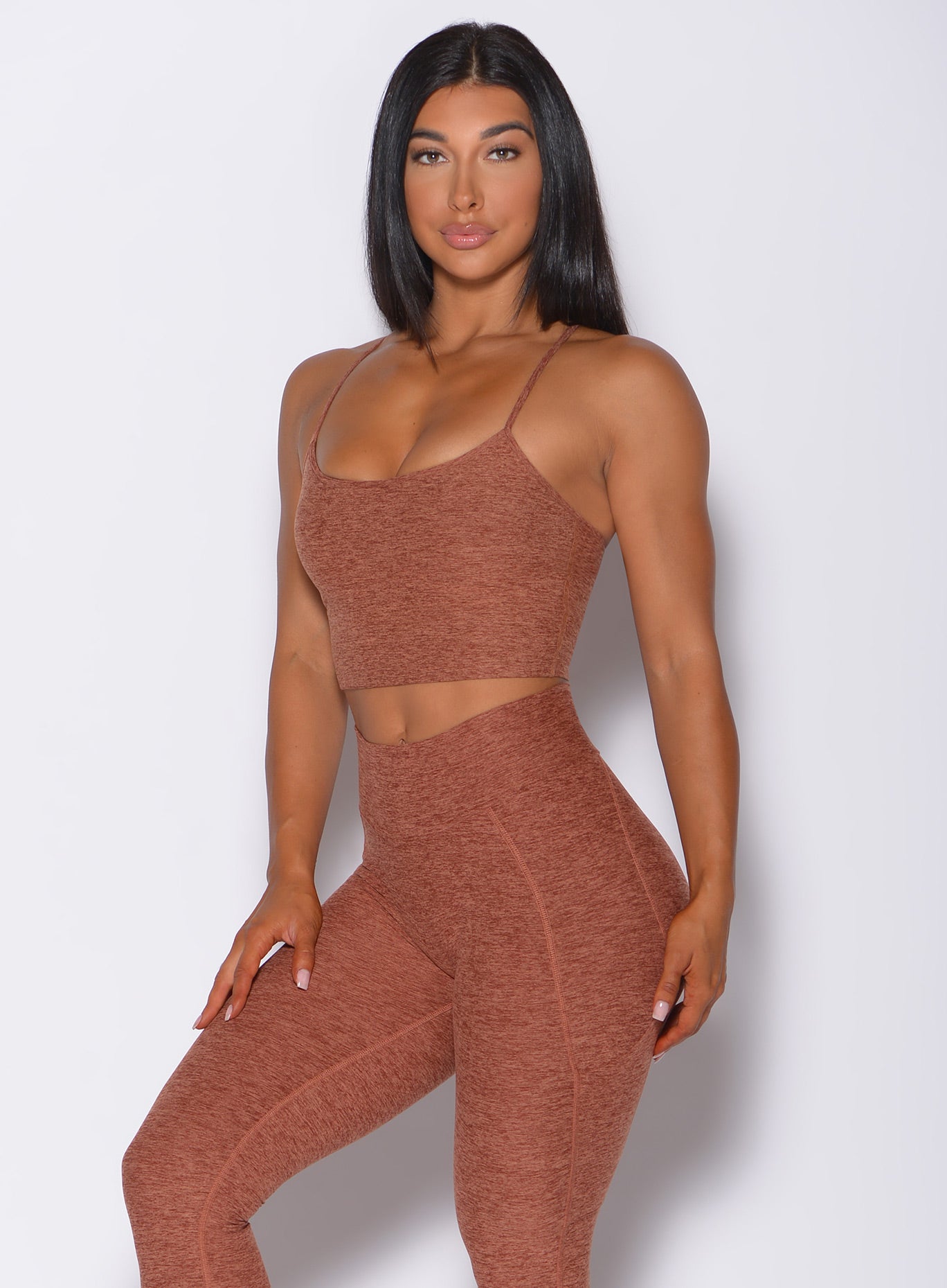 Front profile view of a model facing forward wearing our relax long bra in spiced chai color and a matching leggings