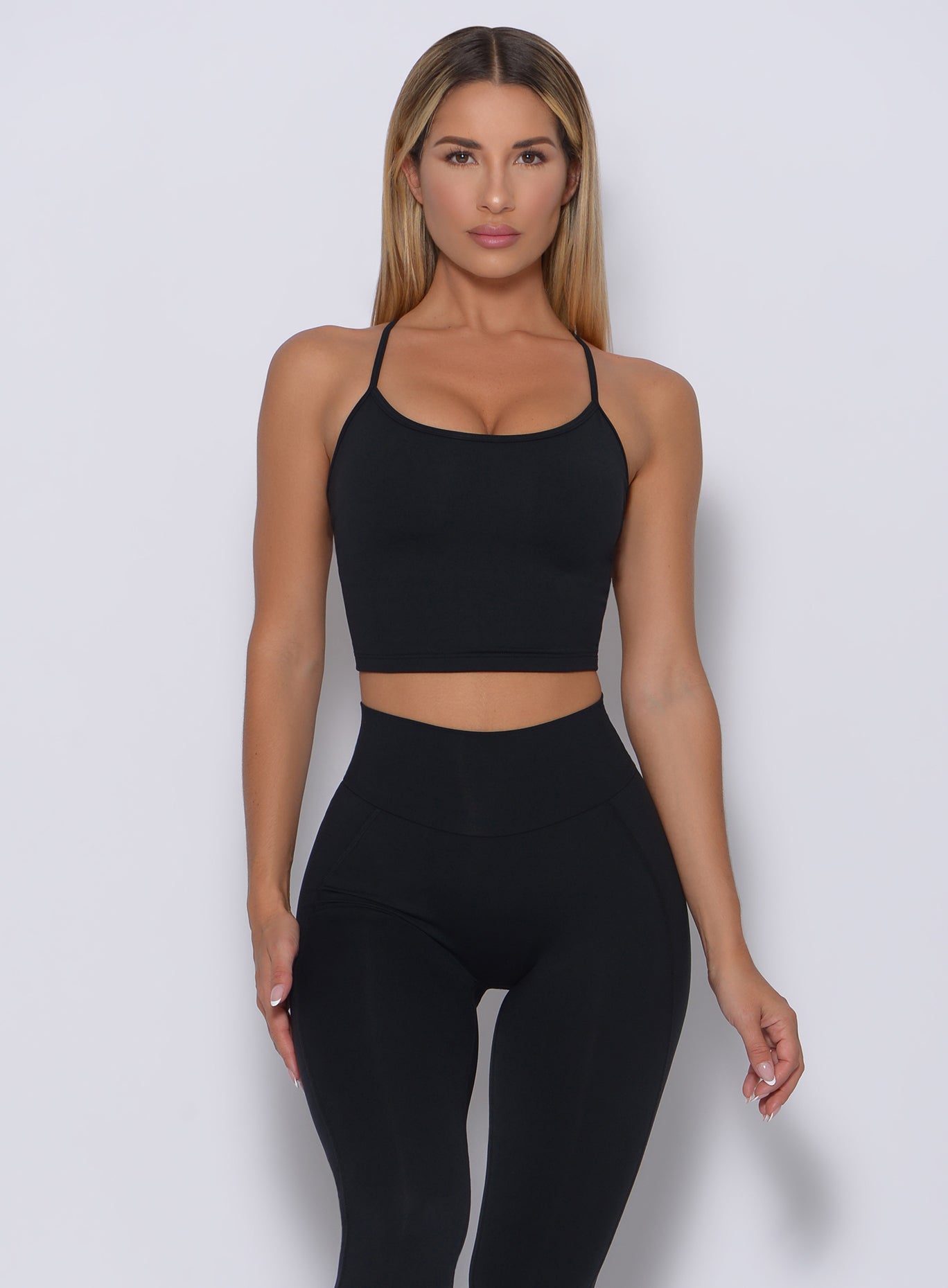 Front profile view of a model wearing our black relax long bra and a matching high waist leggings 
