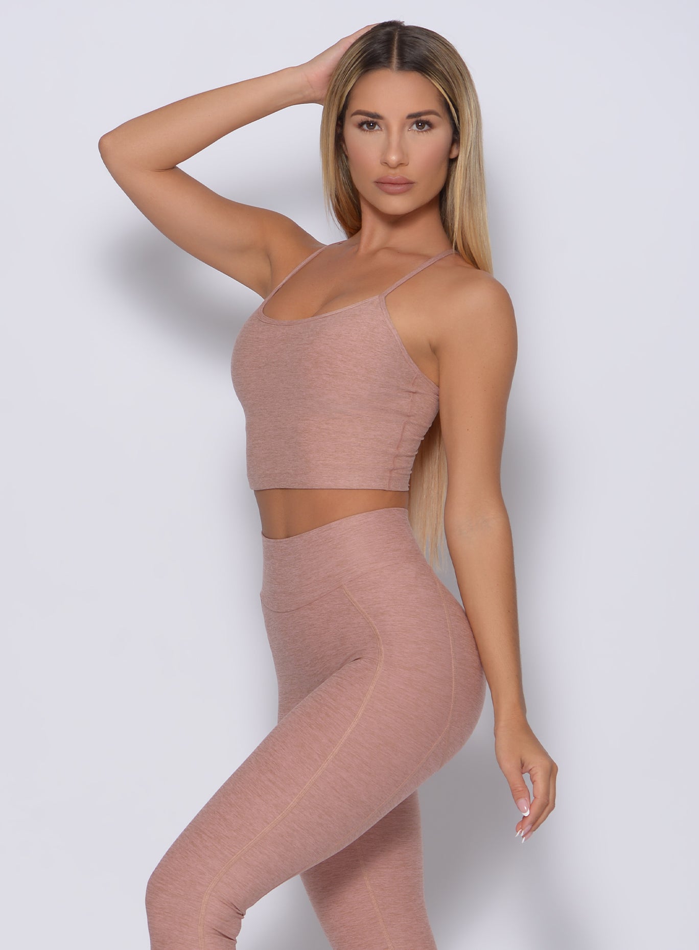 Left side view of a model angled left wearing our relax long bra in latte color and a matching leggings