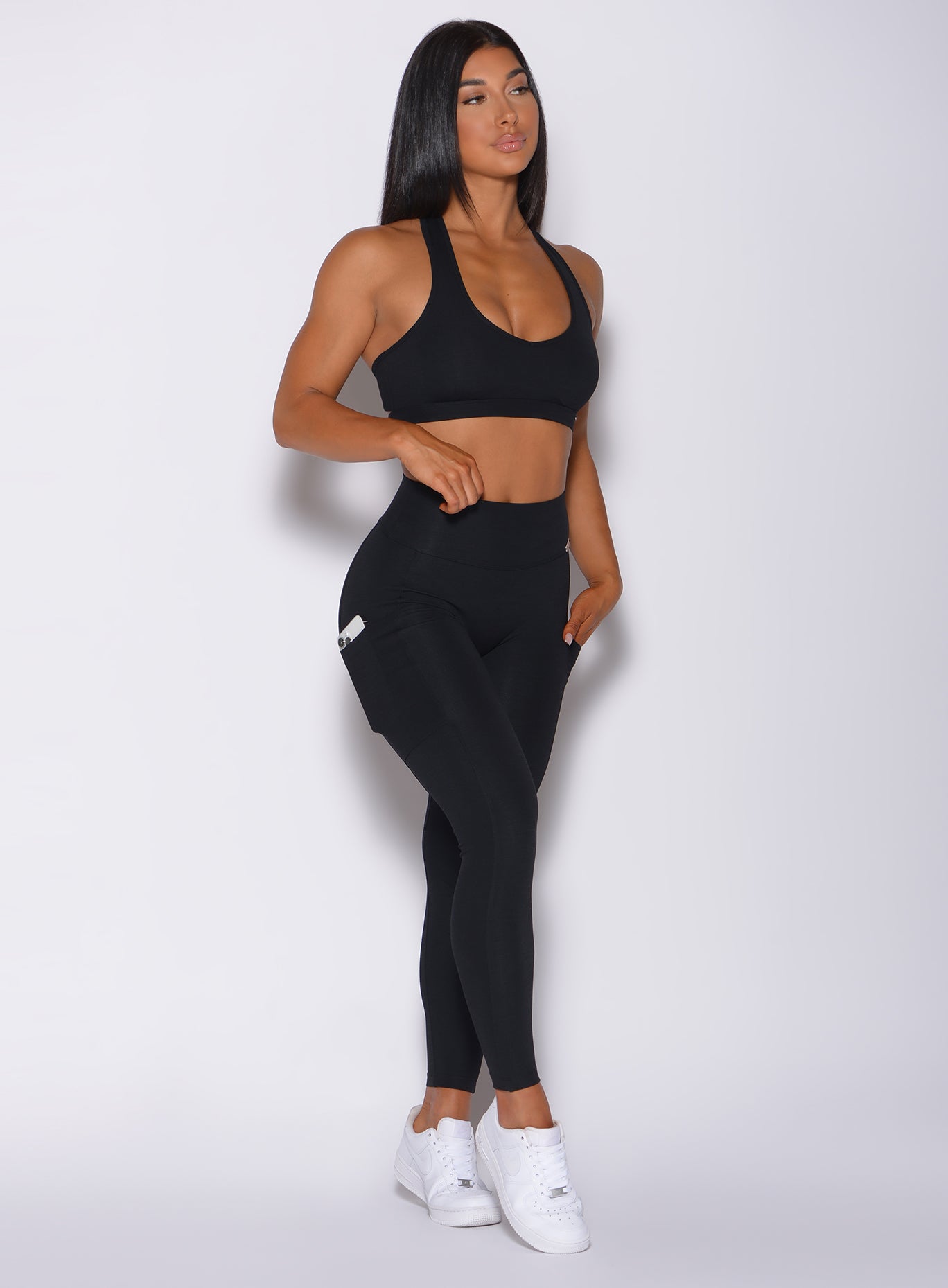 Right side profile view of a model in our black pocket rib leggings and a matching bra