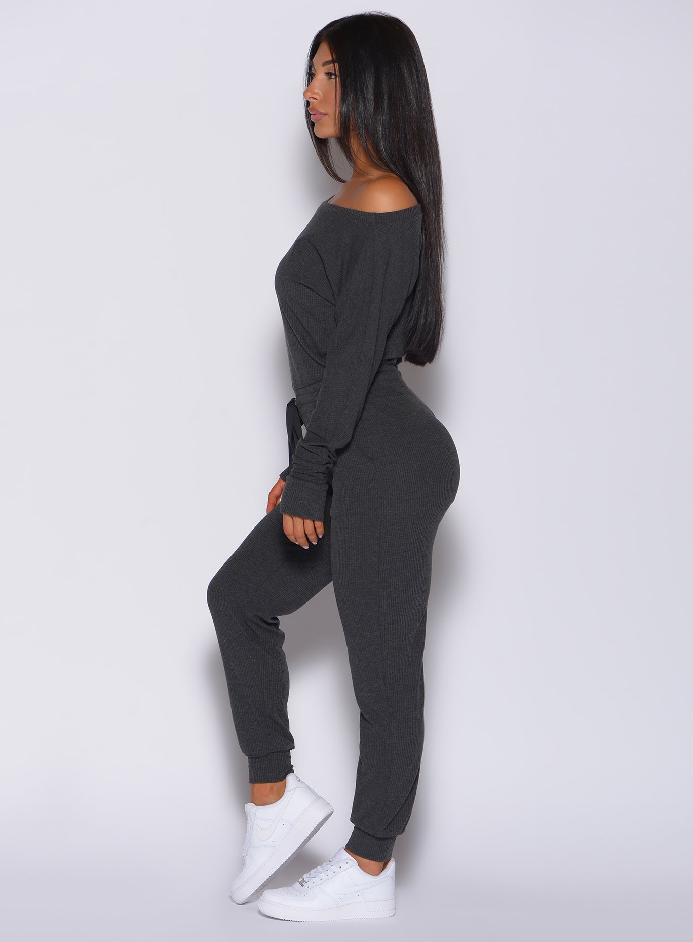 Left side profile view of a model wearing our Rib Jumpsuit in charcoal color 