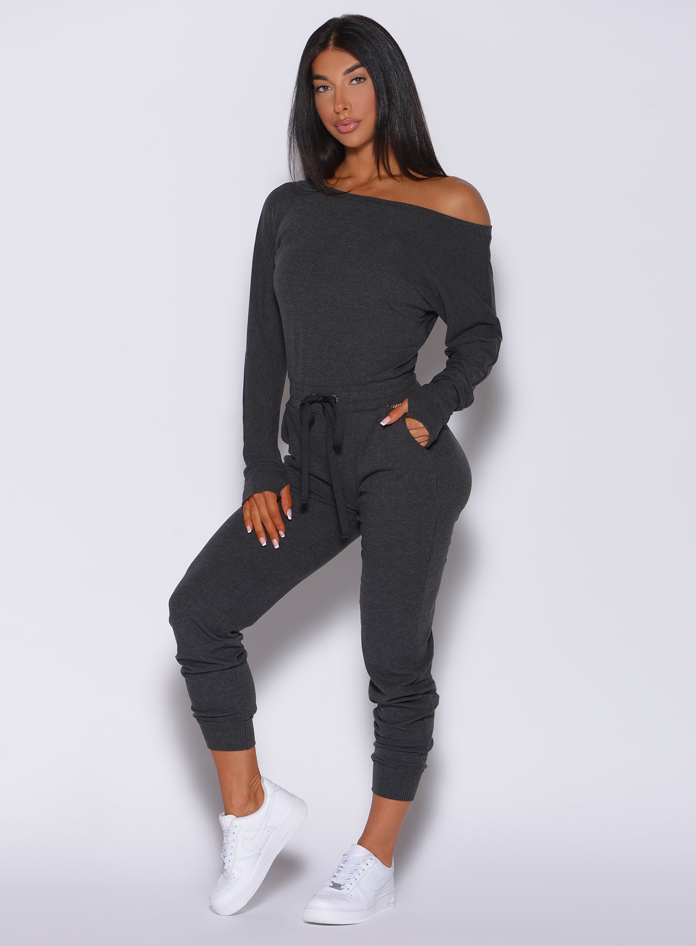 Left side view of a model angled left wearing our Rib Jumpsuit  in charcoal color 