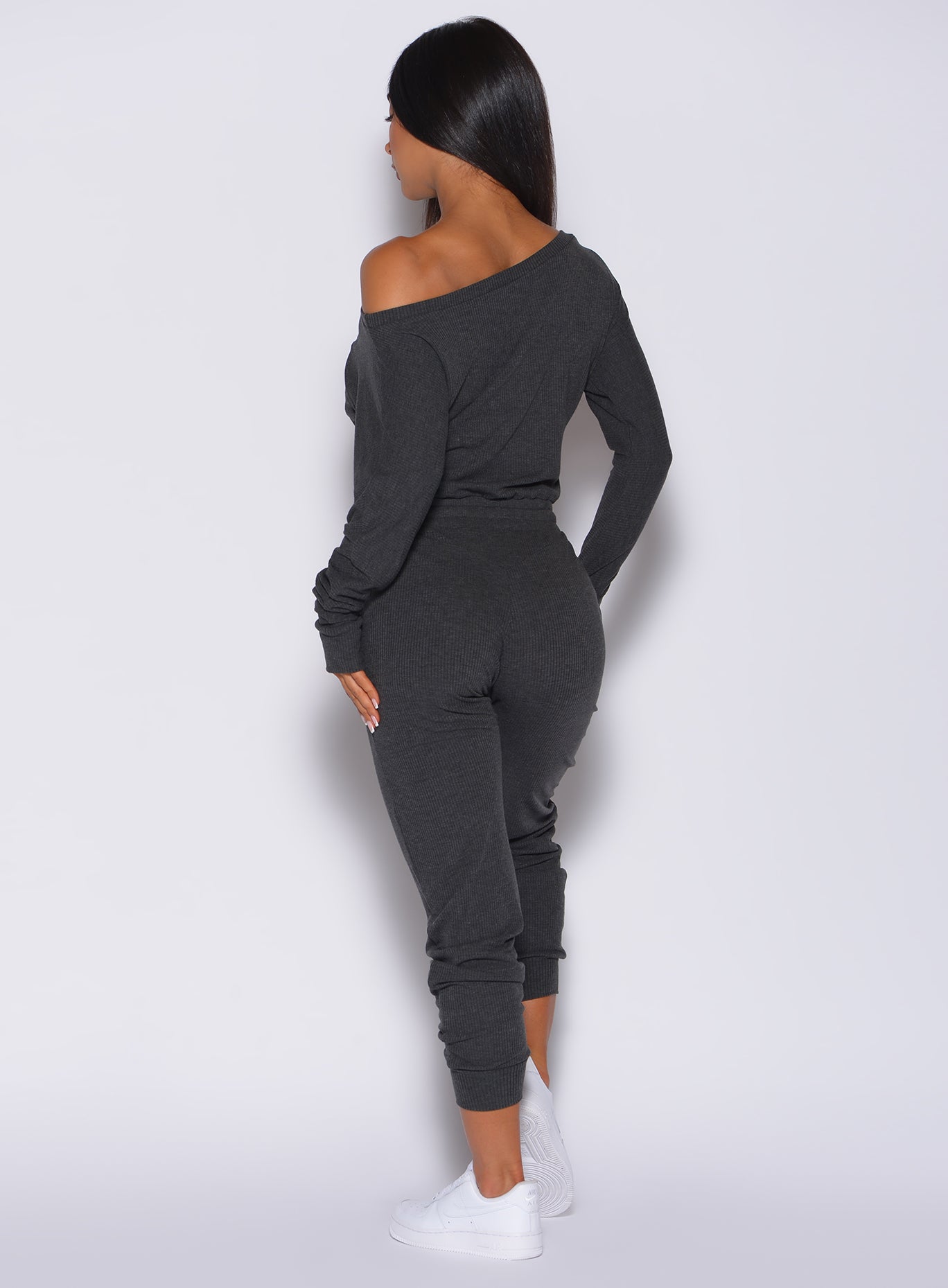 Back profile view of a model wearing our Rib Jumpsuit in charcoal color 