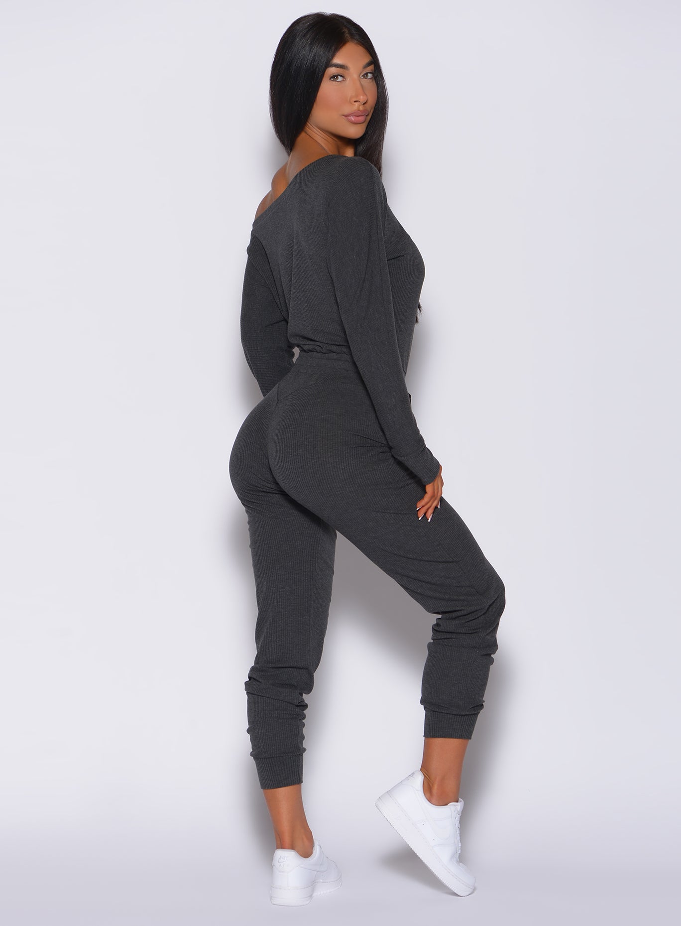 Right side profile view of a model wearing our Rib Jumpsuit in charcoal color 