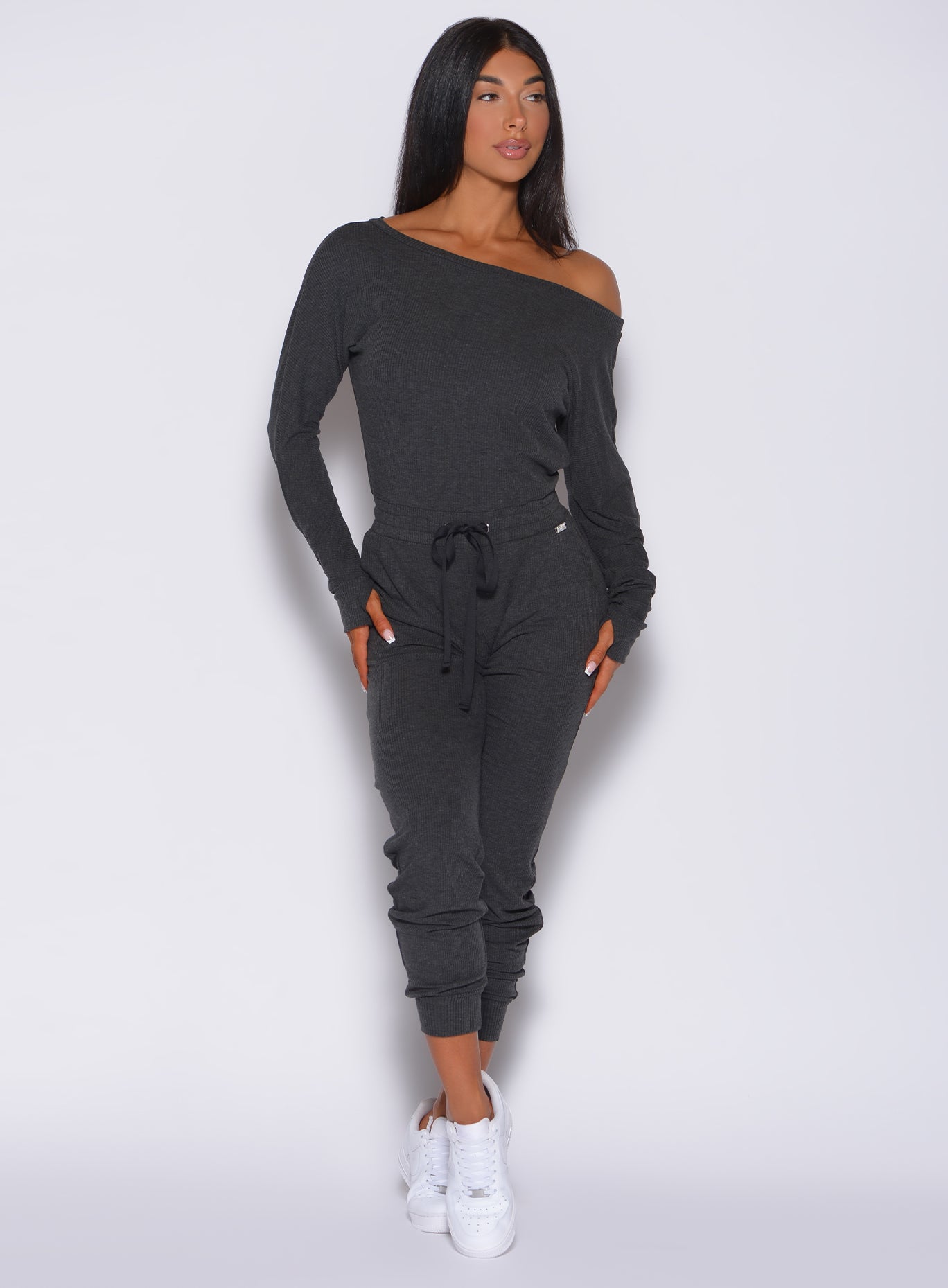 Front profile view of a model wearing our Rib Jumpsuit in charcoal color