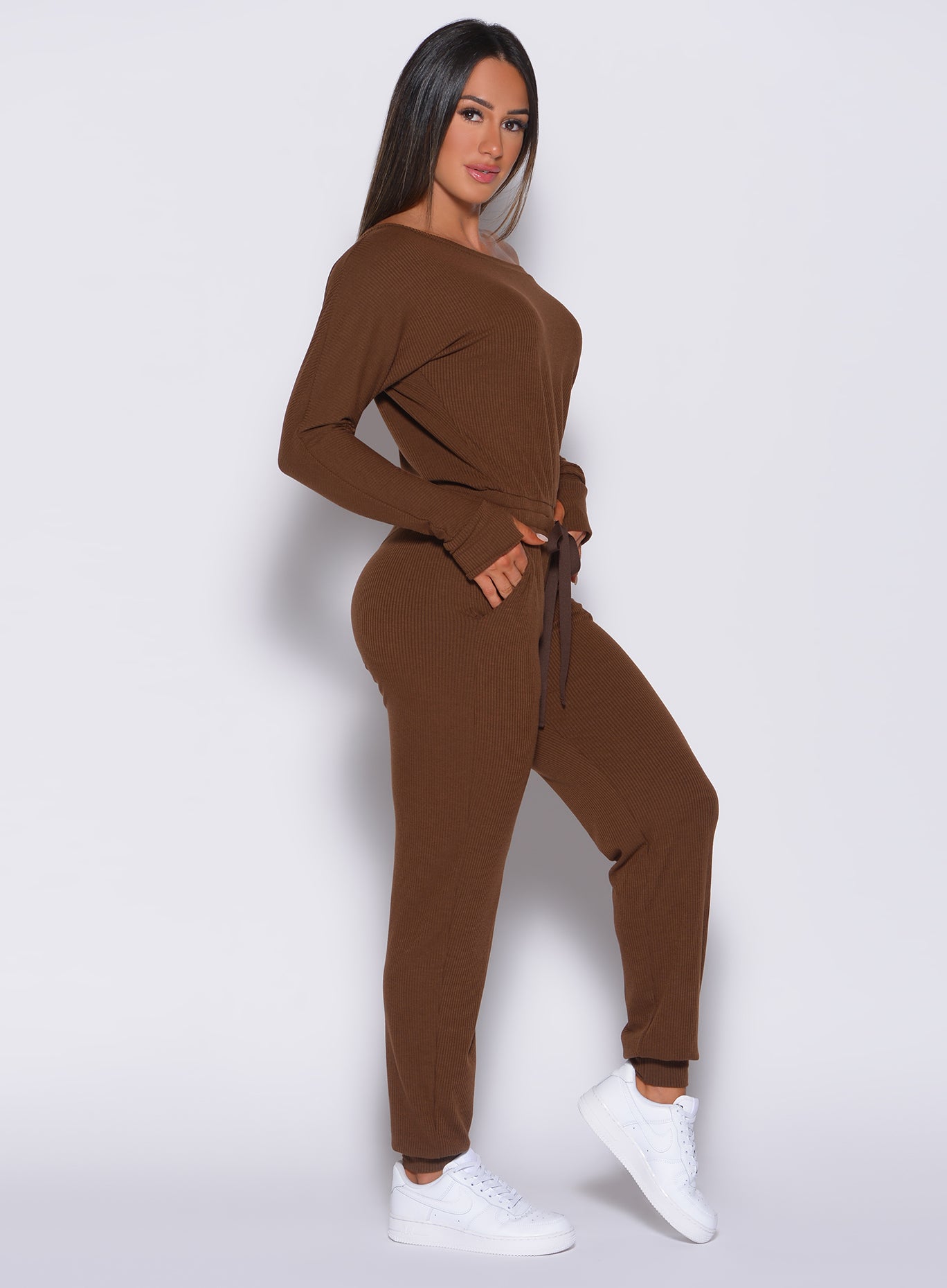 Right side profile view of a model wearing our rib jumpsuit in expresso color 