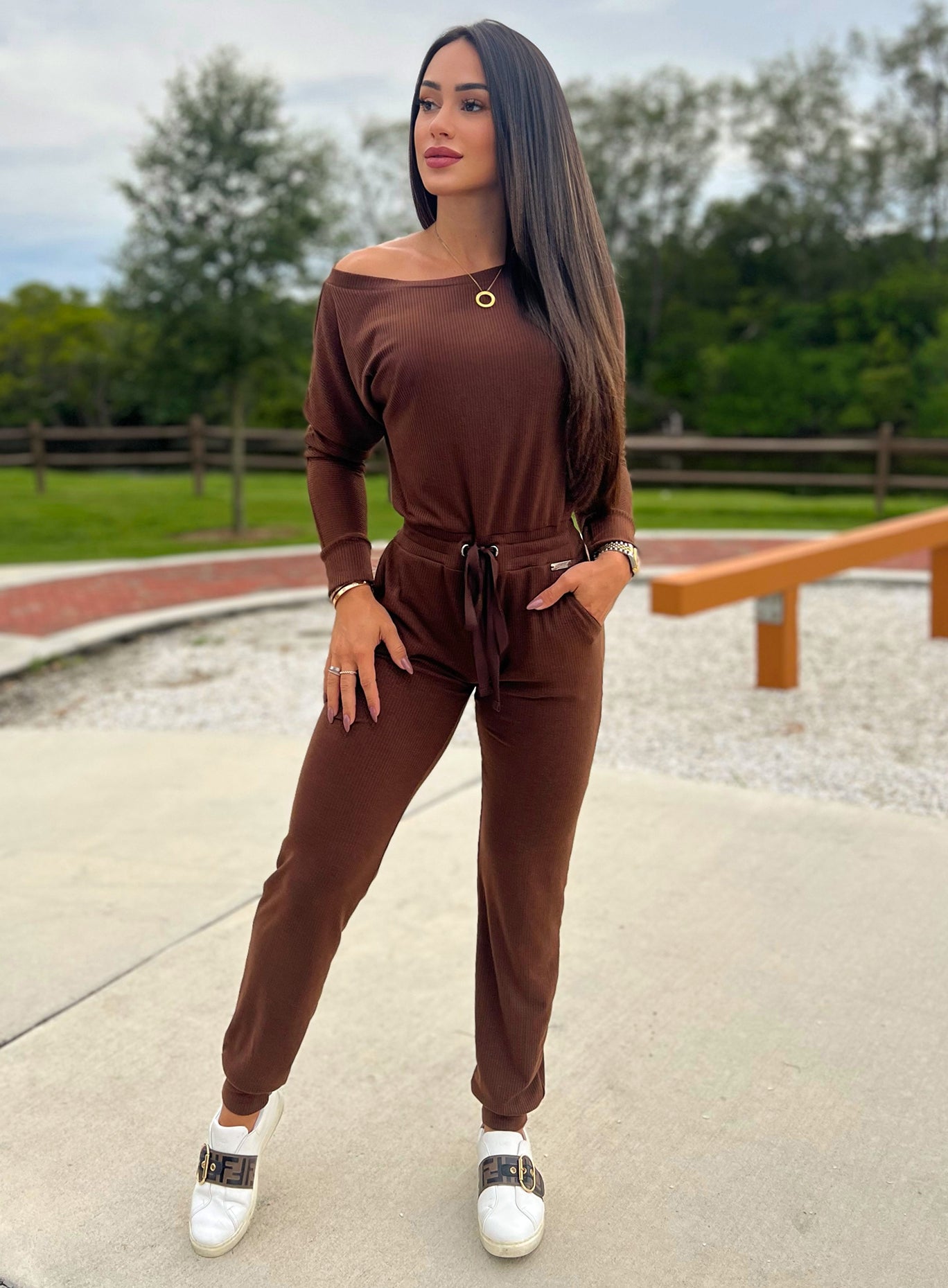 Front profile view of a model wearing our rib jumpsuit in expresso color 