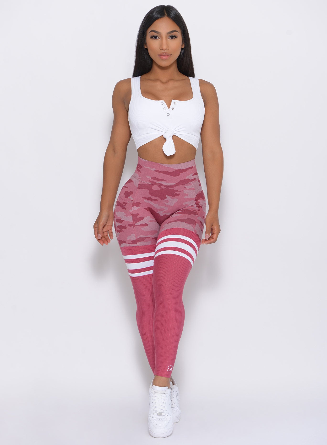 Model facing forward wearing our Scrunch Thigh High in hibiscus camo color and a white top