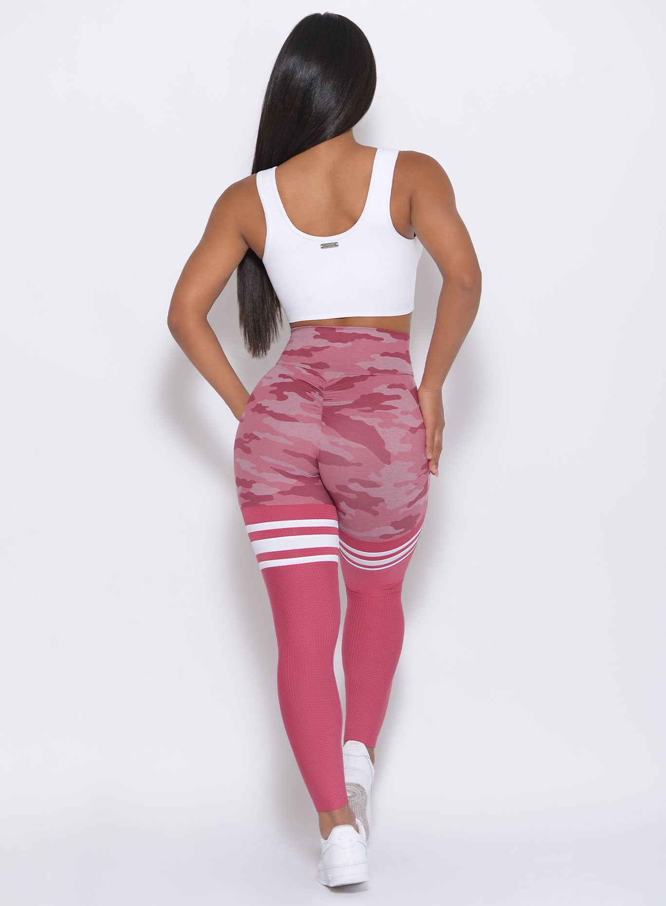 Back view of the model wearing our Scrunch Thigh High in hibiscus camo color and a white top