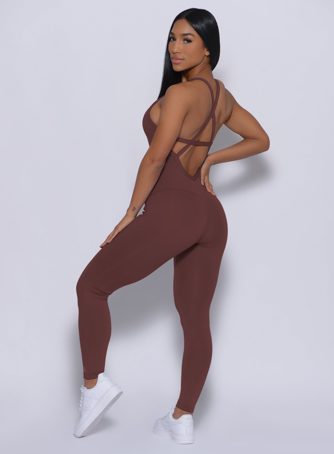 Left side profile view of a model wearing our sculpted bodysuit in chocolate color