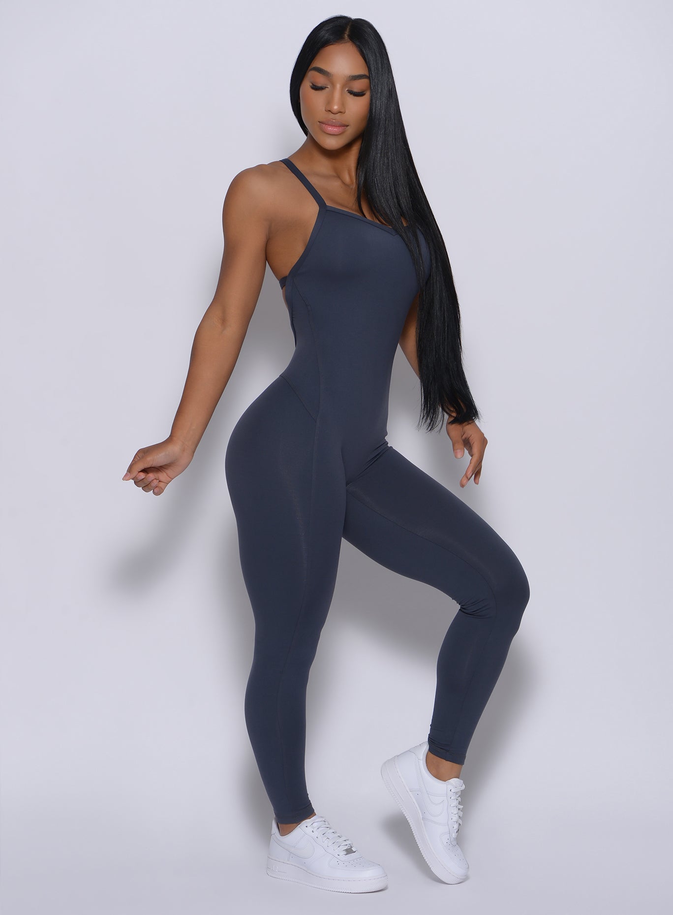 Right side  profile view of a model in our sculpted bodysuit in summit gray color