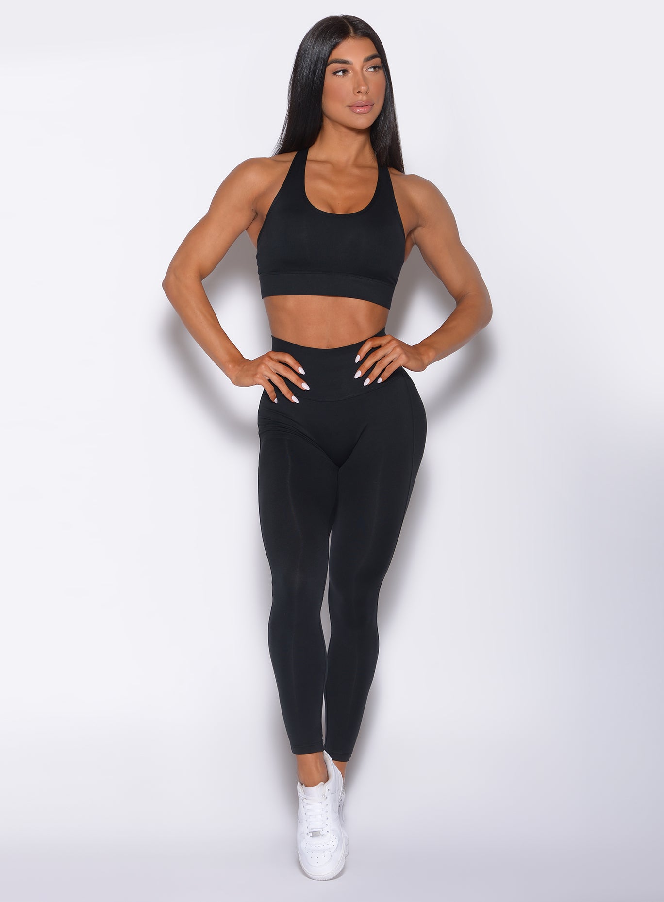Front profile view of a model in our black sexy back leggings and a matching bra 