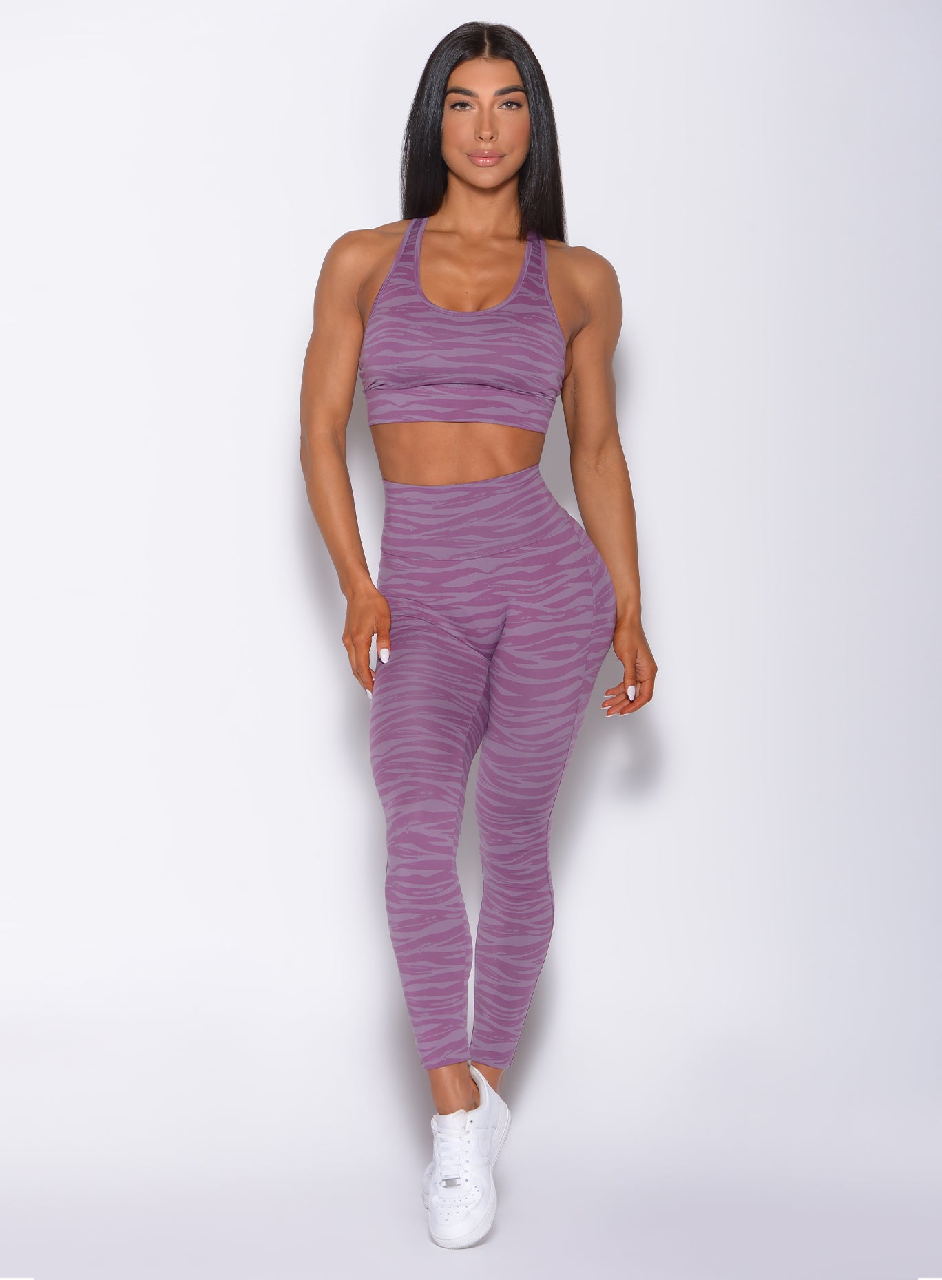 Front profile view of a model in our sexy back legging in tiger orchid purple color and a matching bra 