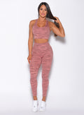 Model facing forward profile wearing our rival sports bra in nude blush color and a matching sexy back leggings in tiger print