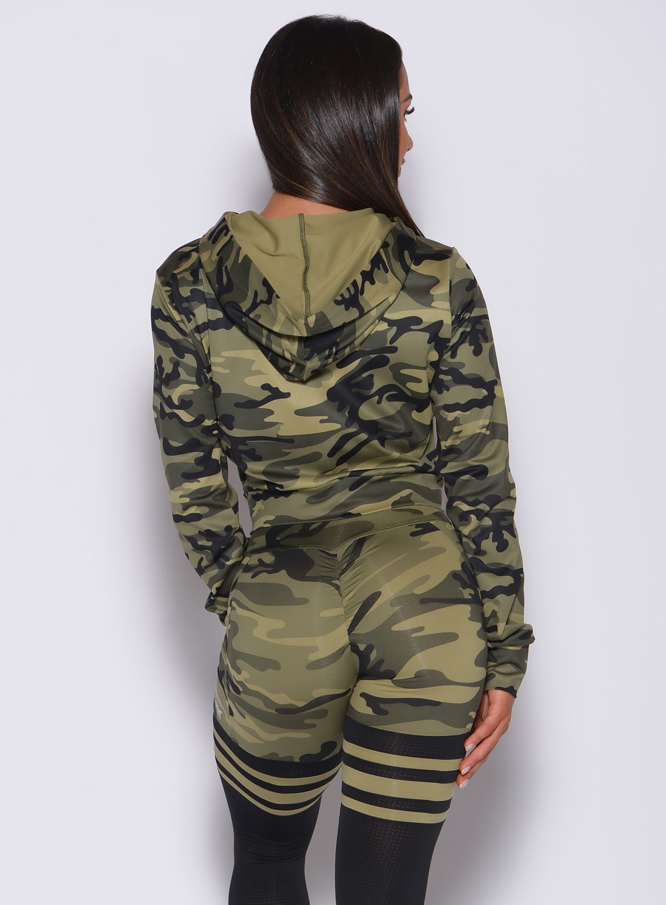Back profile view of a model in our bright army camo signature jacket and a matching thigh high leggings