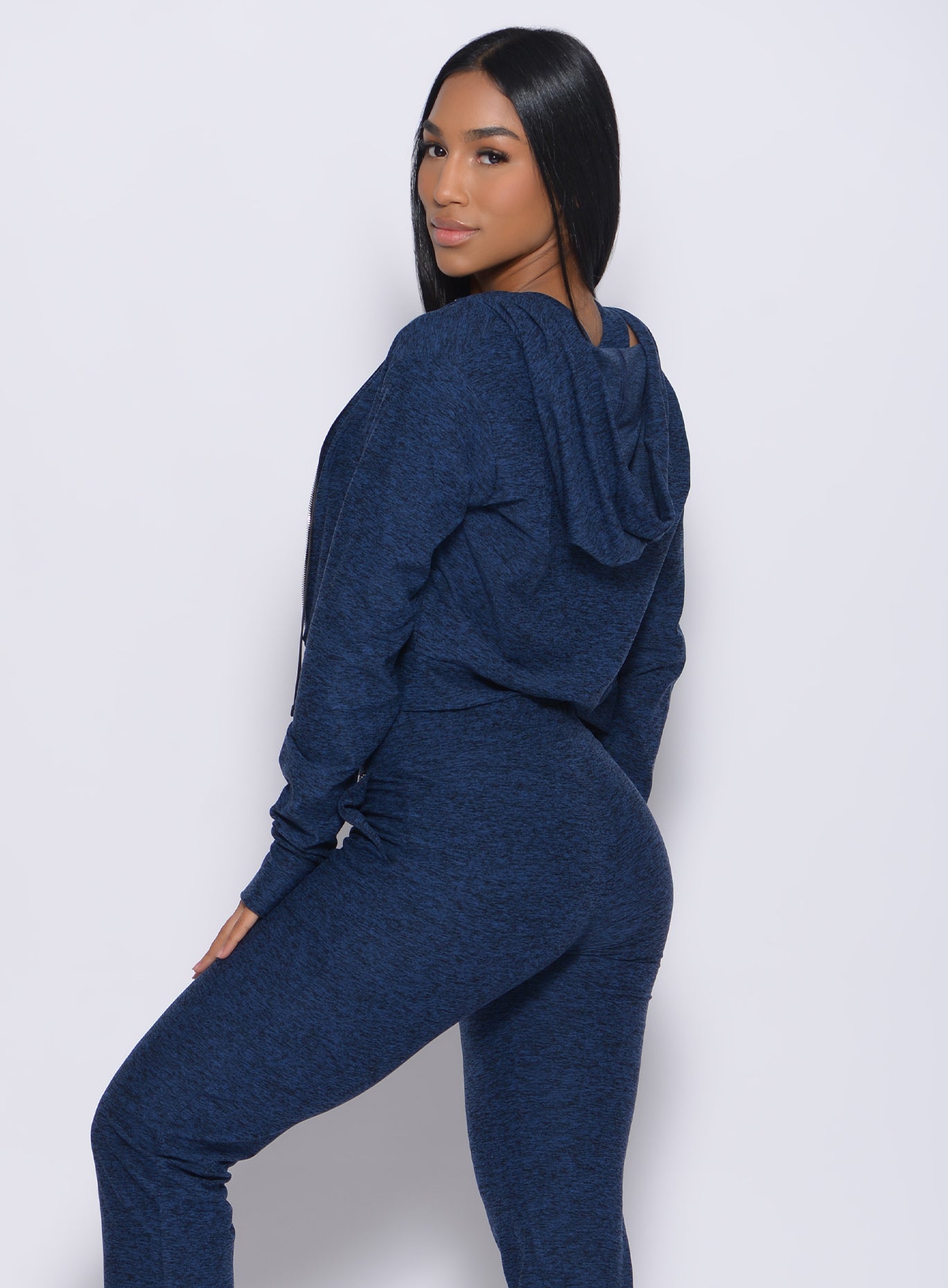 Left side profile view of a model in our signature jacket in sapphire blue color and a matching joggers
