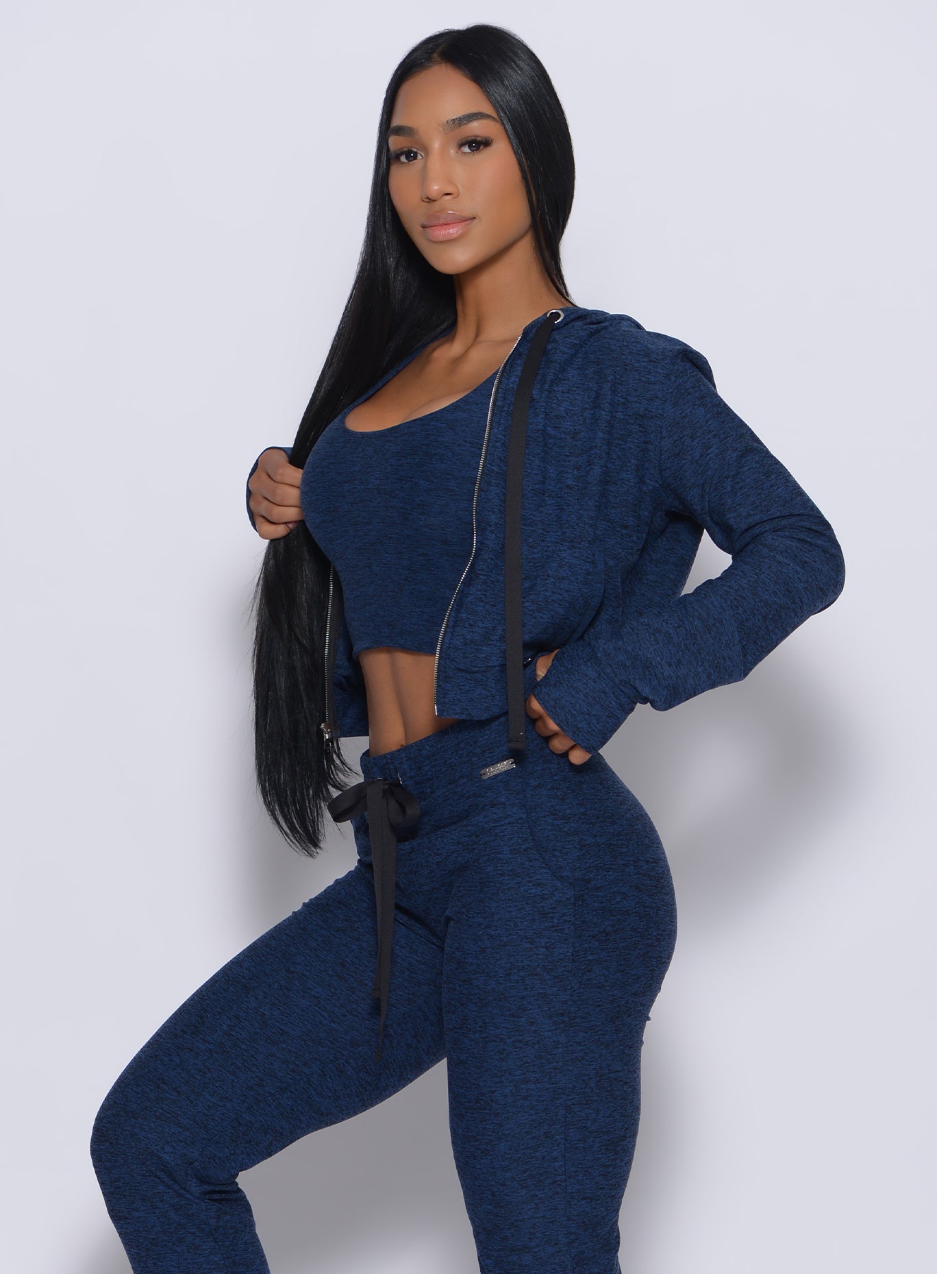Left side profile view of a model angled left wearing our signature jacket in sapphire blue color and a matching joggers