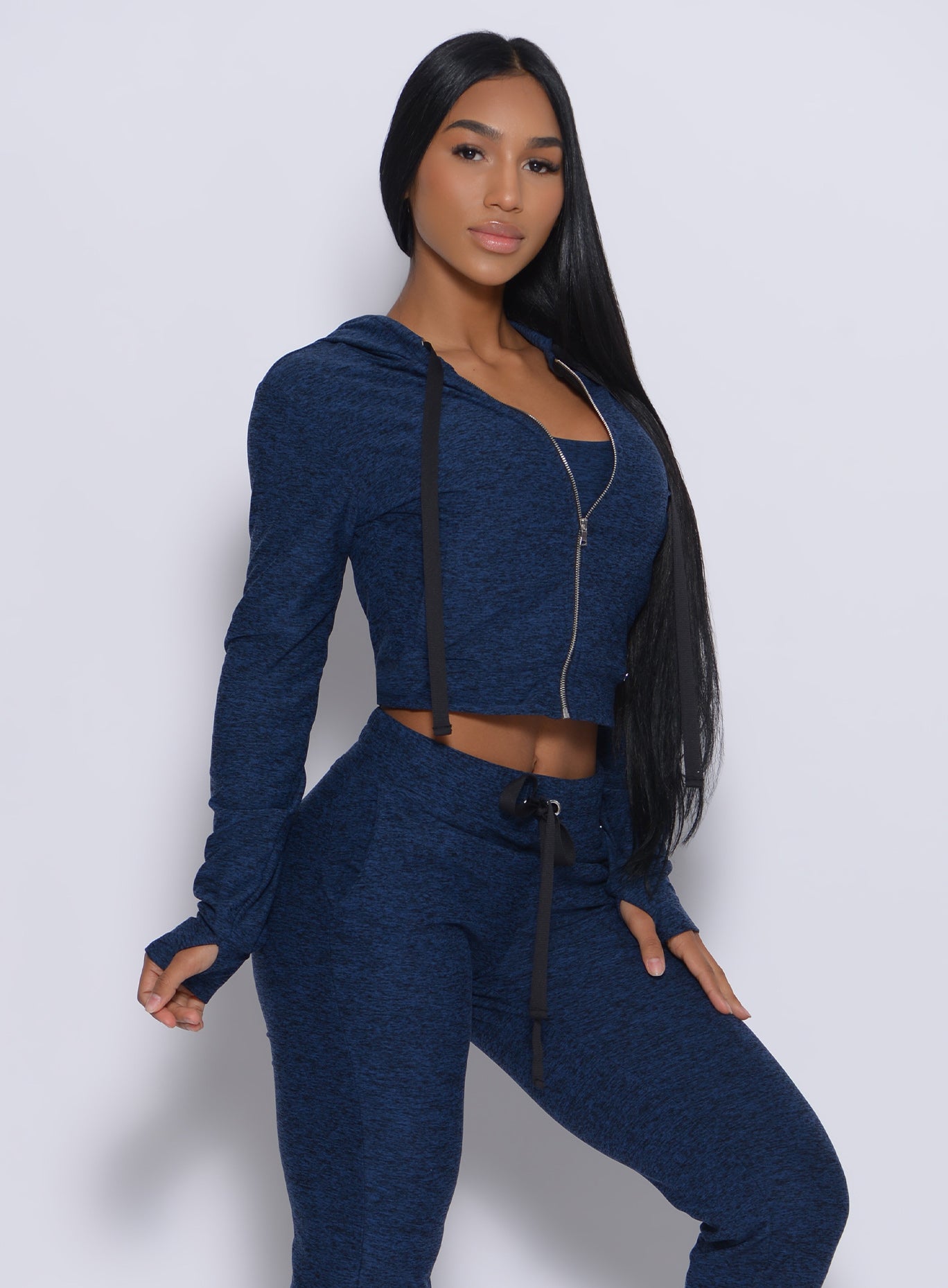 Right side profile view of a model angled right wearing our signature jacket in sapphire blue color and a matching joggers 