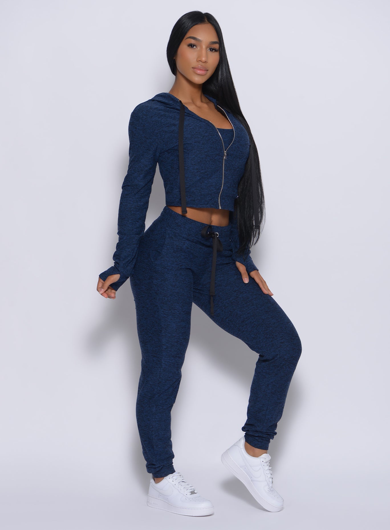 Right side profile view of a model angled right wearing our signature jacket in sapphire blue color and a matching bottom
