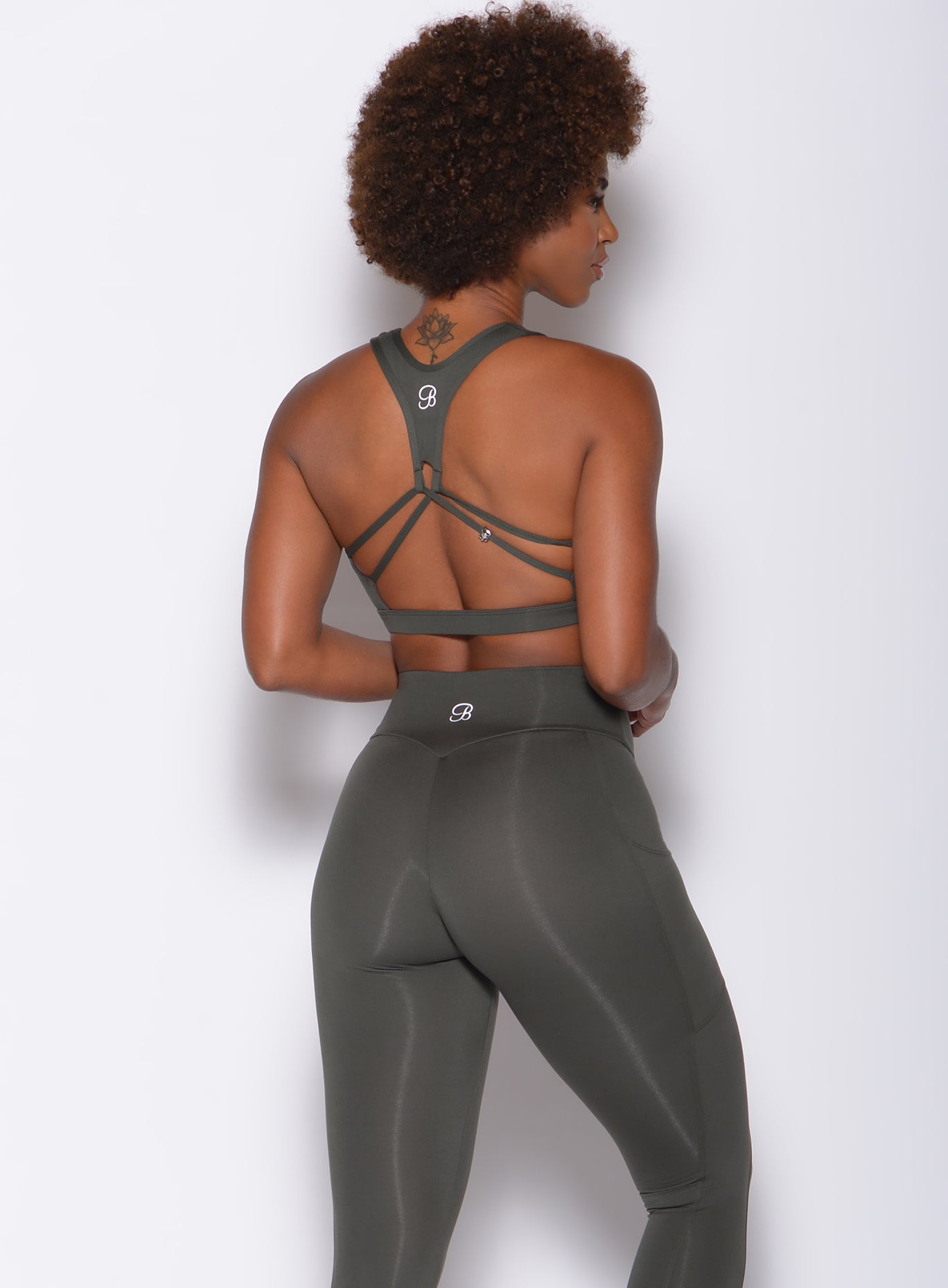 back view of model in a cute strappy back sports bra with a kettlebell skull charm detail