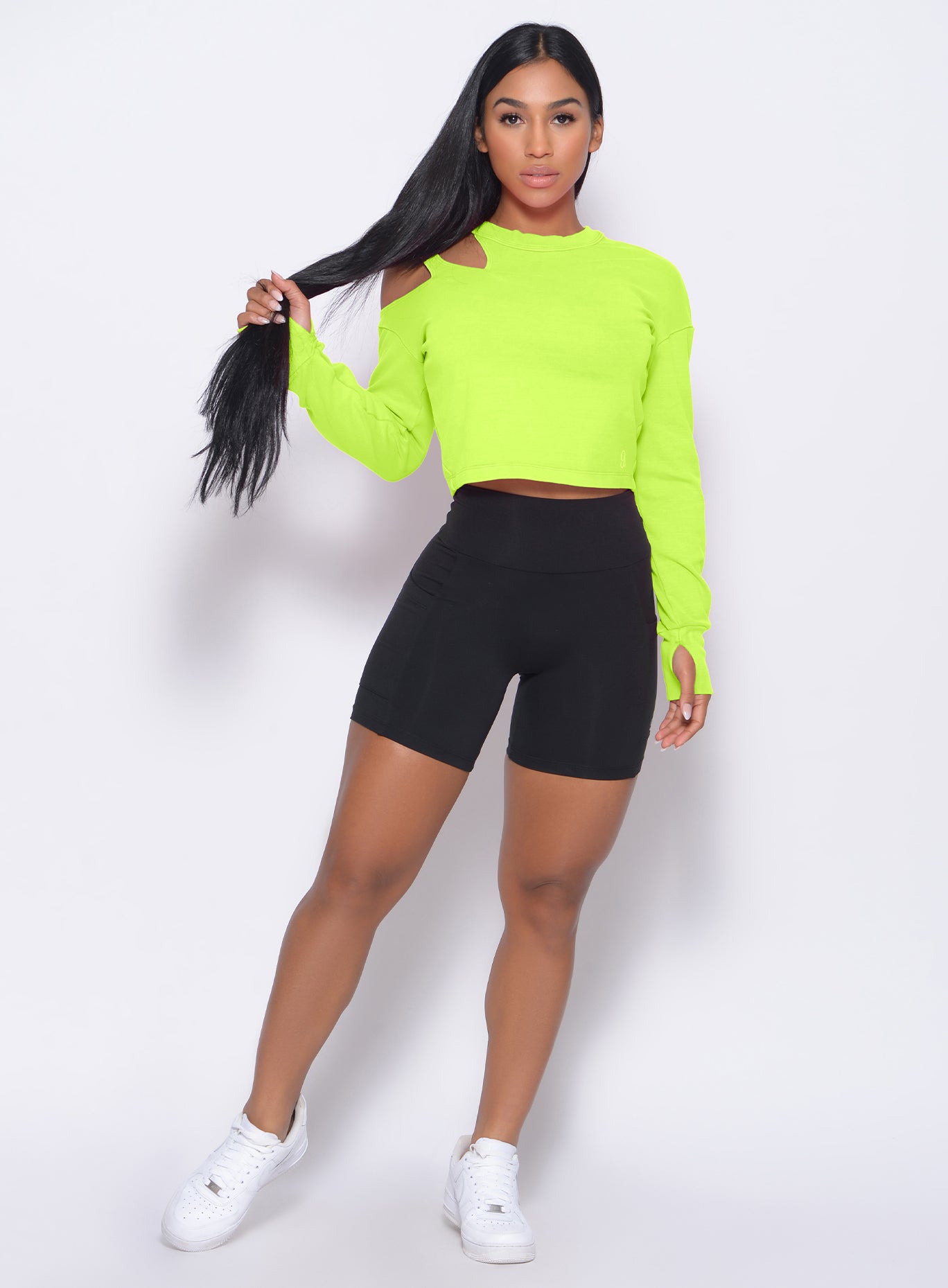Model facing forward wearing our black pocket biker shorts and a neon pink pullover